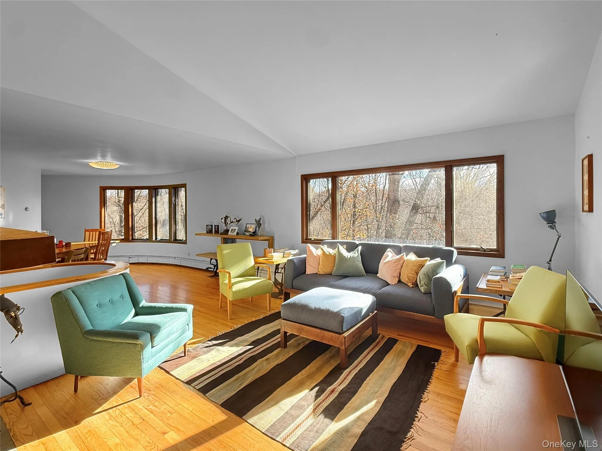 Bright, sunny living room with oversized windows and access to full length screened in porch overlooking acres of open fields Bright, sunny living room with oversized windows and access to full length screened in porch overlooking acres of open fields