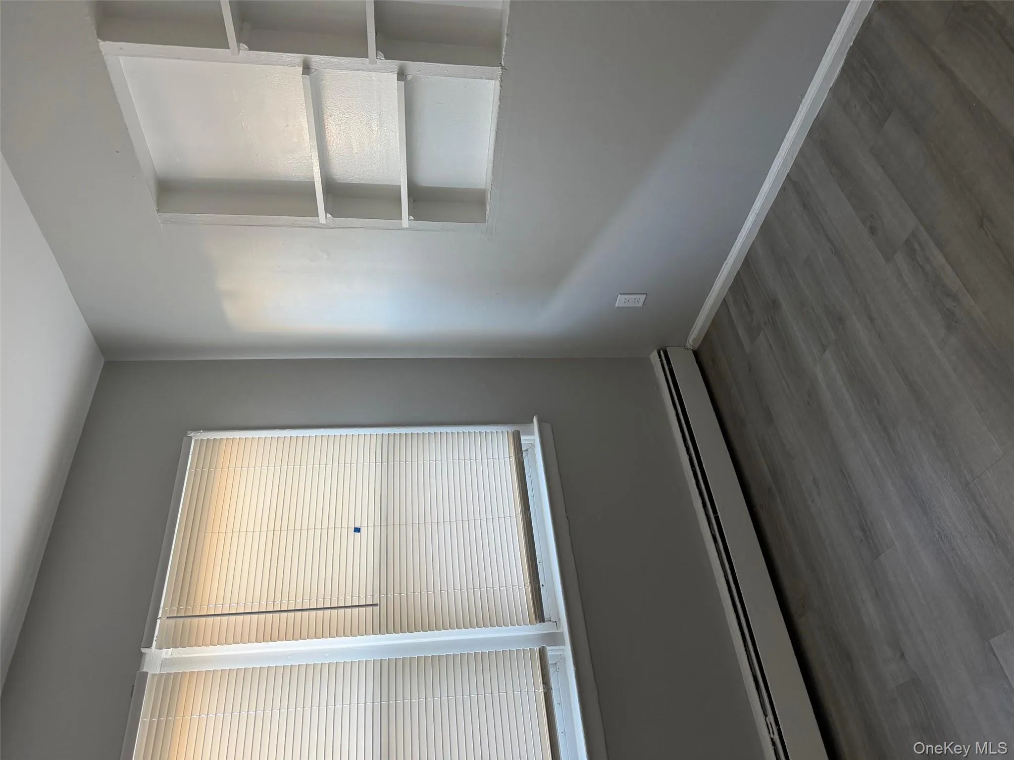 Spare room featuring a baseboard heating unit and dark wood-style floors Spare room featuring a baseboard heating unit and dark wood-style floors