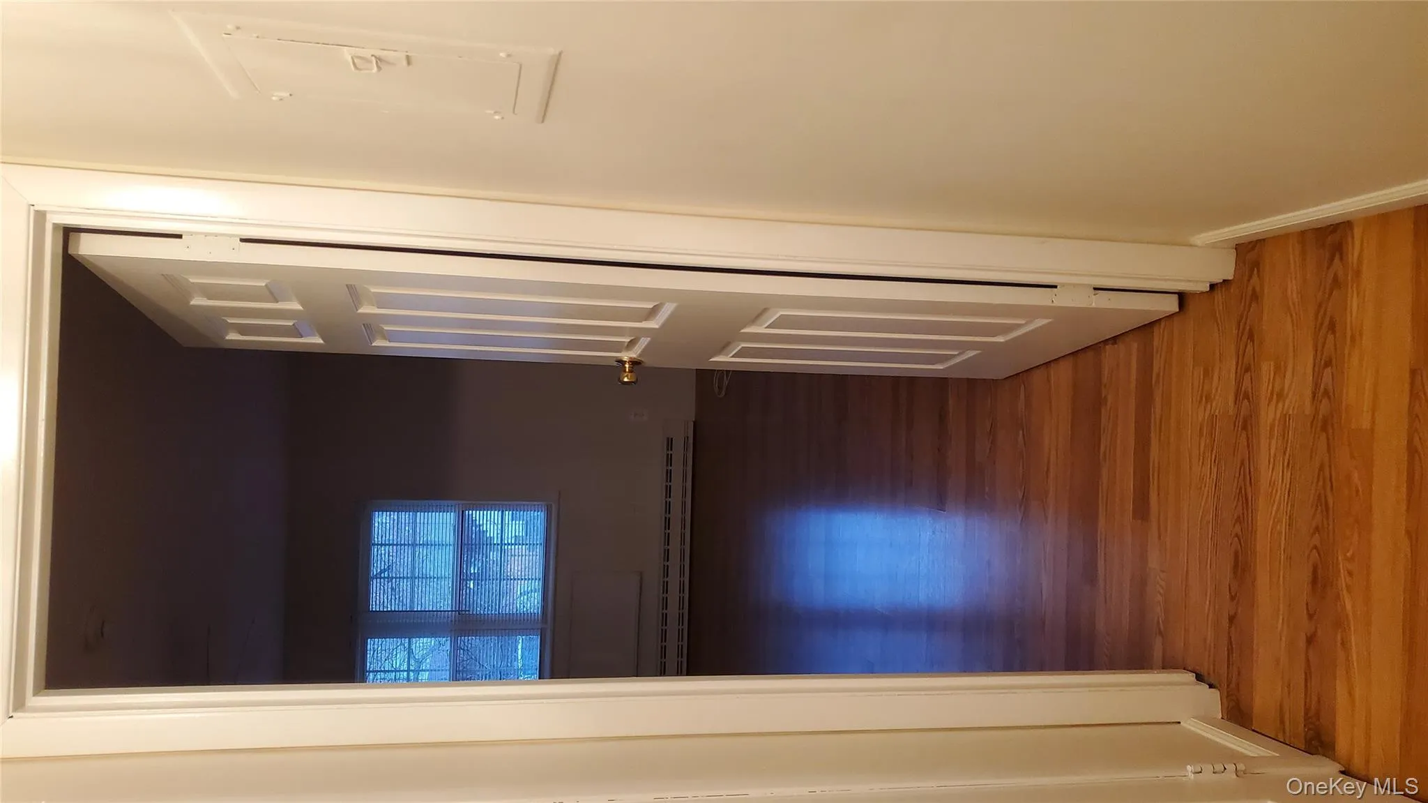 Corridor featuring light wood-style flooring, electric panel, and a baseboard radiator Corridor featuring light wood-style flooring, electric panel, and a baseboard radiator