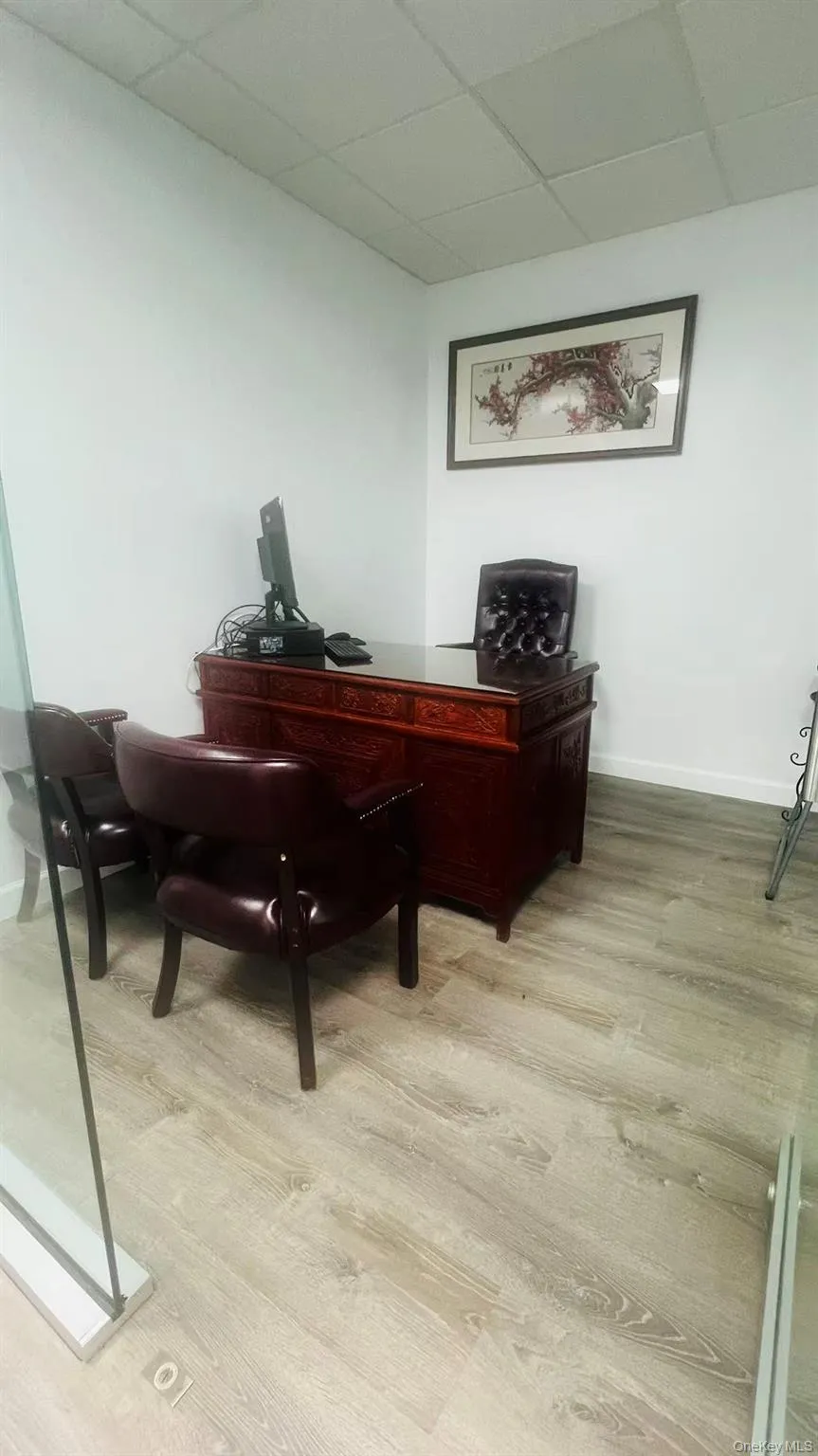 Office space featuring a paneled ceiling and light wood-style floors Office space featuring a paneled ceiling and light wood-style floors