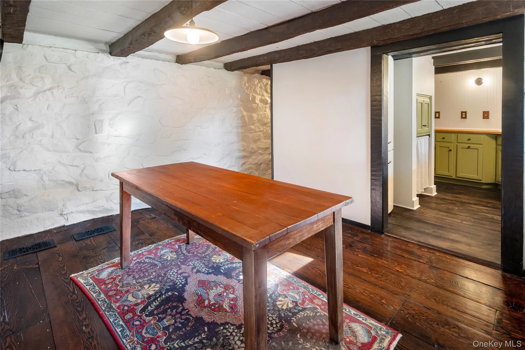 Ground level dining room with beautiful wide plank hardwood flooring and a ceiling with exposed beams Ground level dining room with beautiful wide plank hardwood flooring and a ceiling with exposed beams