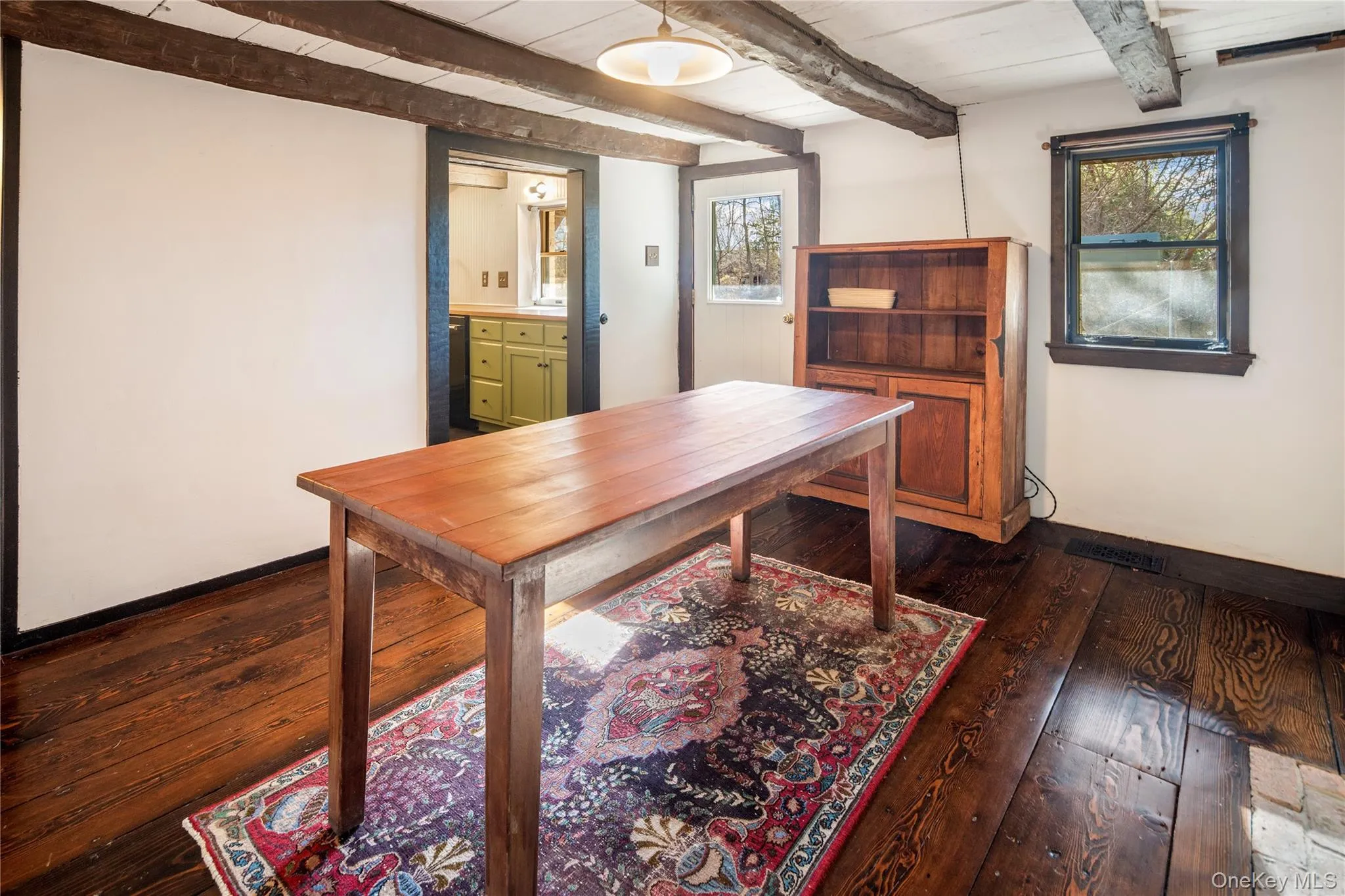 Ground level dining room with beautiful wide plank hardwood flooring and a ceiling with exposed beams Ground level dining room with beautiful wide plank hardwood flooring and a ceiling with exposed beams