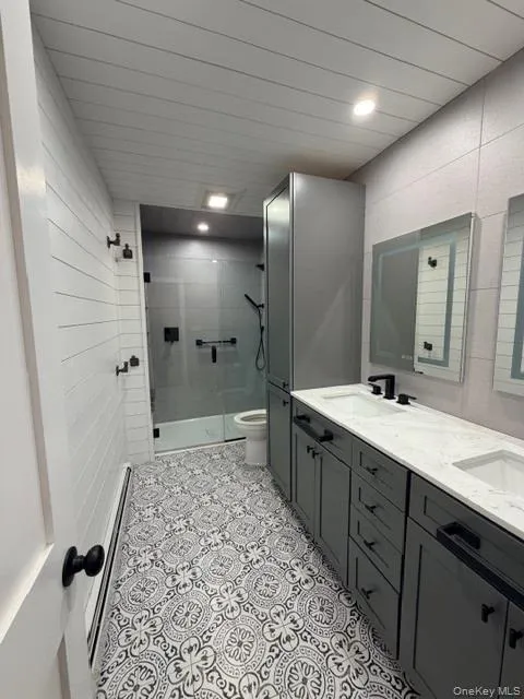 Full bathroom featuring double vanity, a shower stall, and recessed lighting Full bathroom featuring double vanity, a shower stall, and recessed lighting