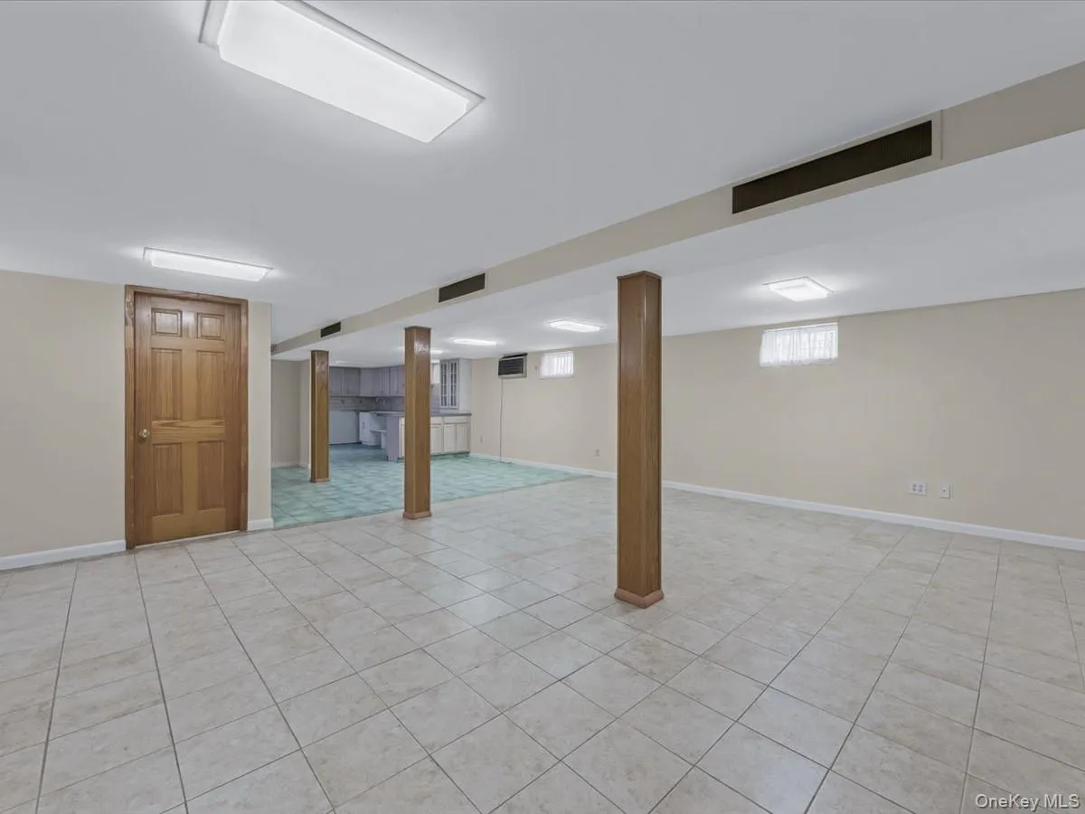 Basement featuring baseboards and light tile patterned floors Basement featuring baseboards and light tile patterned floors