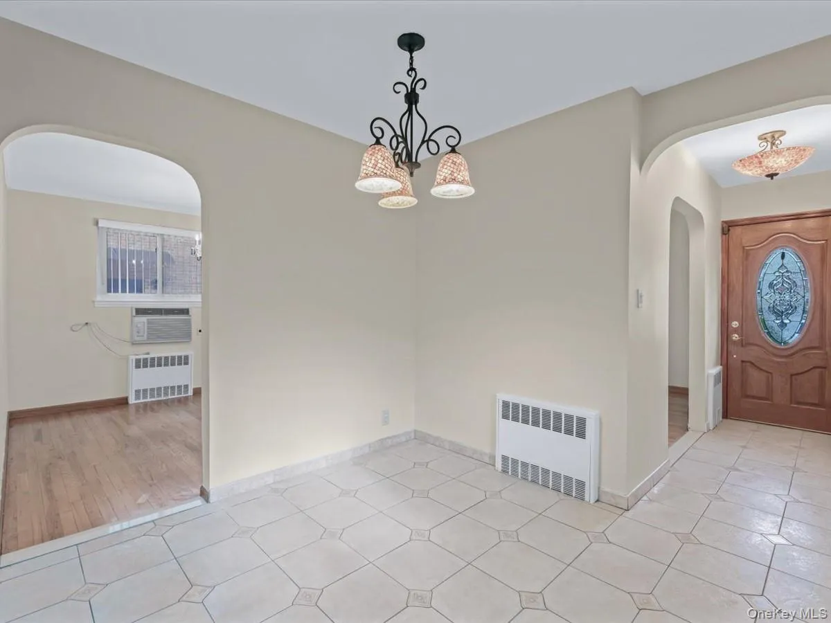 Eat in kitchen area featuring arched walkways, radiator heating unit, and a chandelier Eat in kitchen area featuring arched walkways, radiator heating unit, and a chandelier