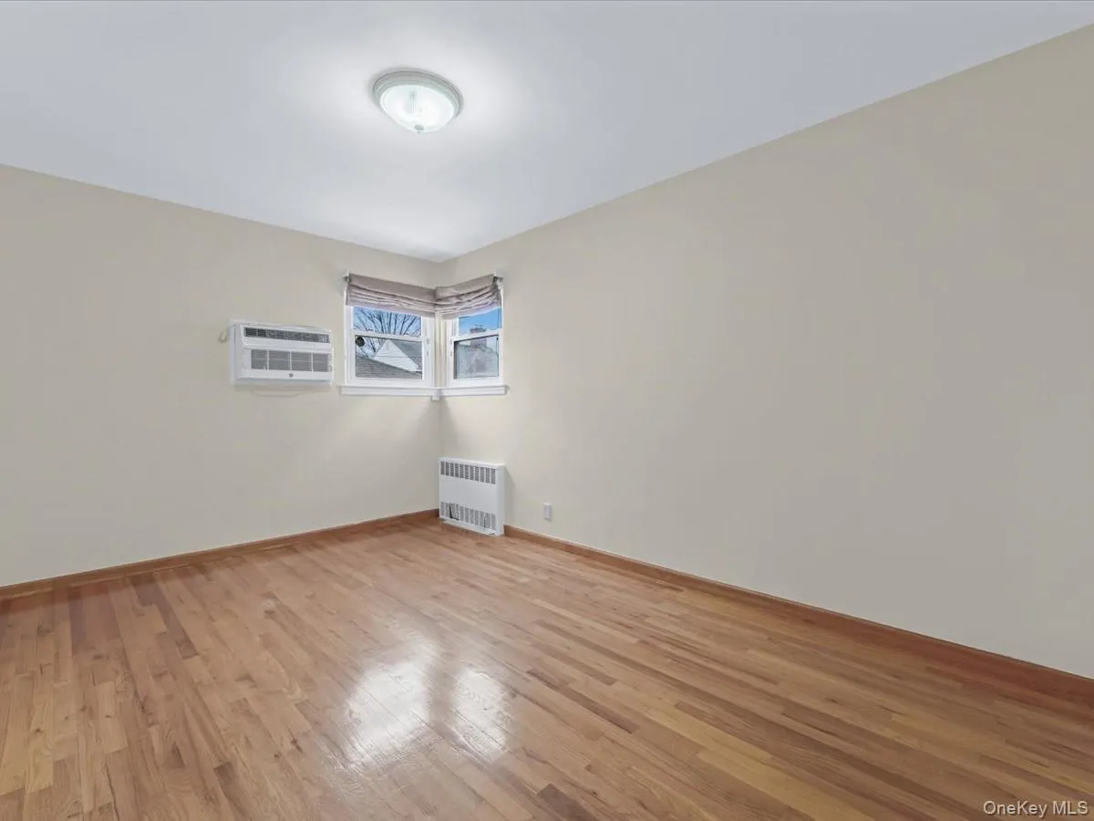 2nd bedroom featuring light wood-style floors and radiator 2nd bedroom featuring light wood-style floors and radiator