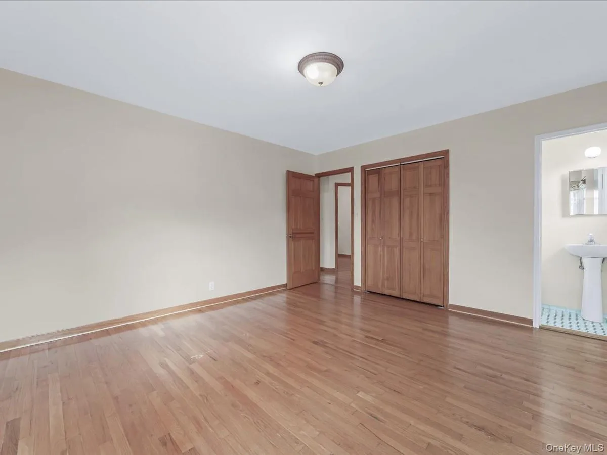 Primary bedroom with light wood-type flooring and a closet Primary bedroom with light wood-type flooring and a closet