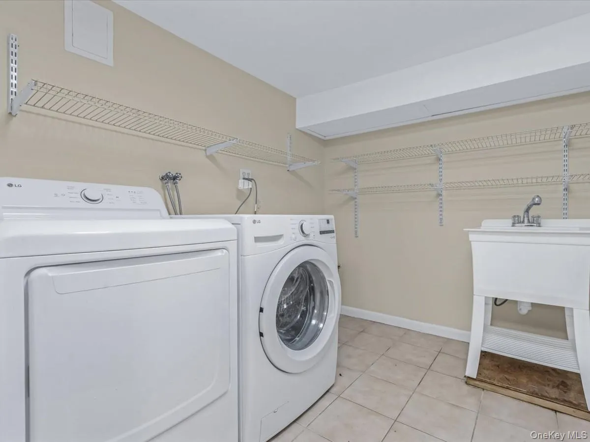 Washroom featuring washing machine and dryer and light tile patterned flooring Washroom featuring washing machine and dryer and light tile patterned flooring