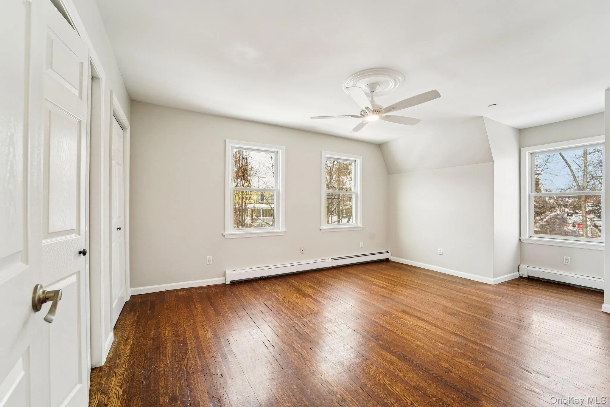Additional living space featuring hardwood / wood-style floors, a baseboard radiator, lofted ceiling, a ceiling fan Additional living space featuring hardwood / wood-style floors, a baseboard radiator, lofted ceiling, a ceiling fan