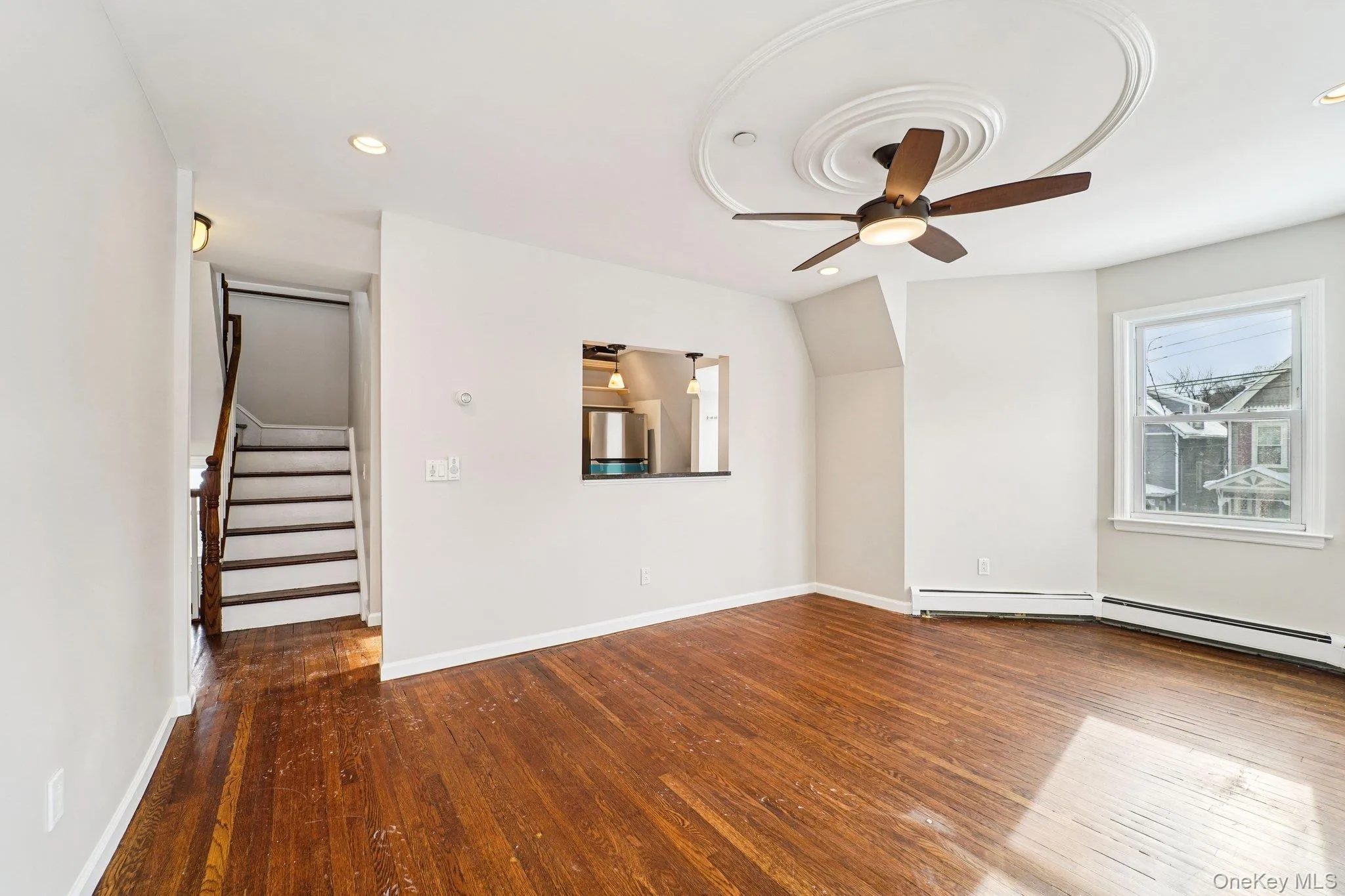 Unfurnished living room featuring stairs, dark wood-style floors, ceiling fan, and recessed lighting Unfurnished living room featuring stairs, dark wood-style floors, ceiling fan, and recessed lighting