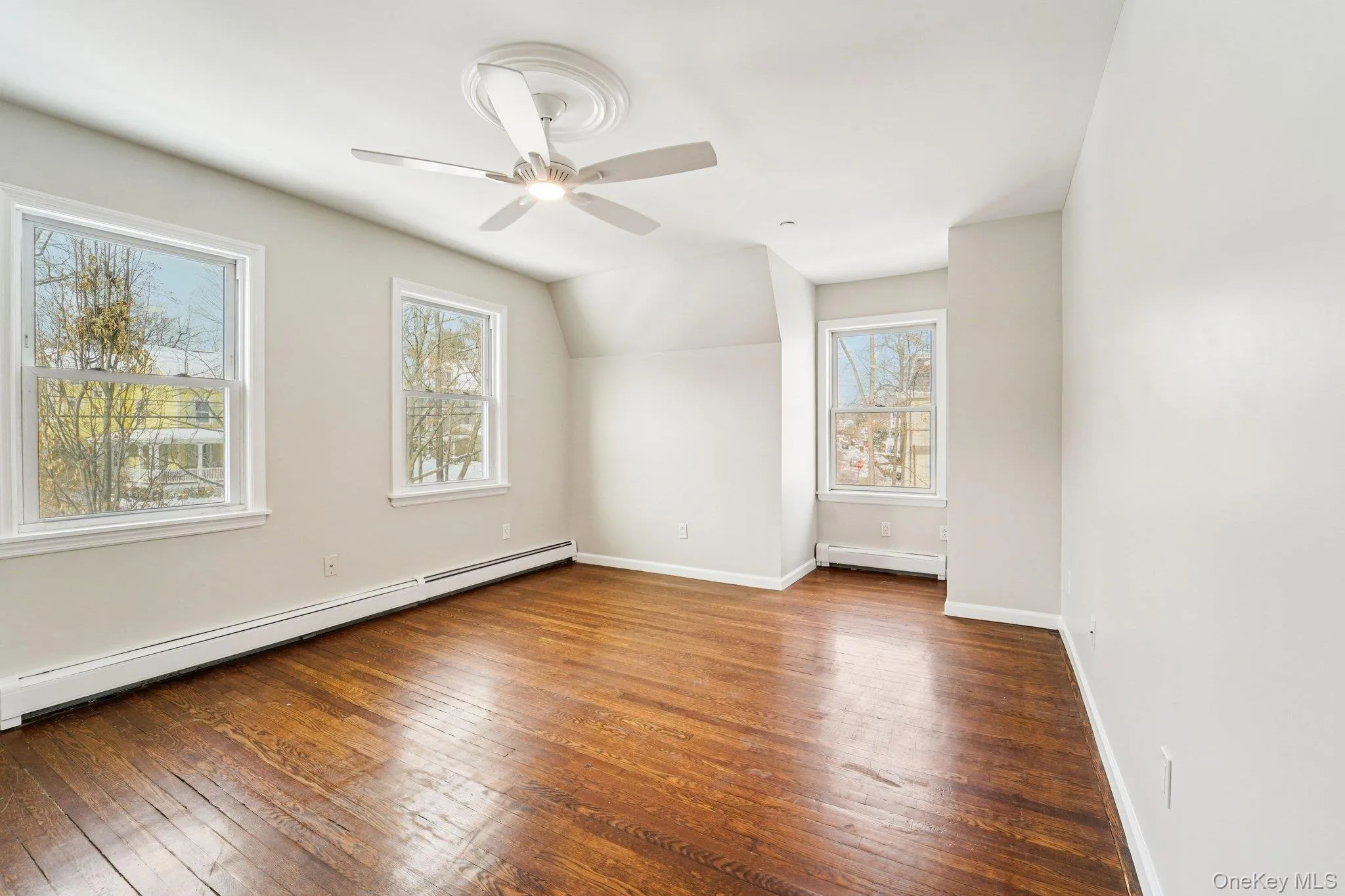 Bonus room featuring wood-type flooring, baseboard heating, vaulted ceiling, a baseboard radiator, and a ceiling fan Bonus room featuring wood-type flooring, baseboard heating, vaulted ceiling, a baseboard radiator, and a ceiling fan