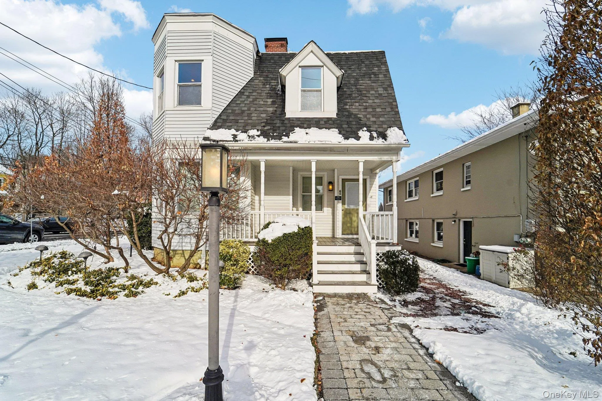 View of front of house featuring a shingled roof, covered porch, and a chimney View of front of house featuring a shingled roof, covered porch, and a chimney
