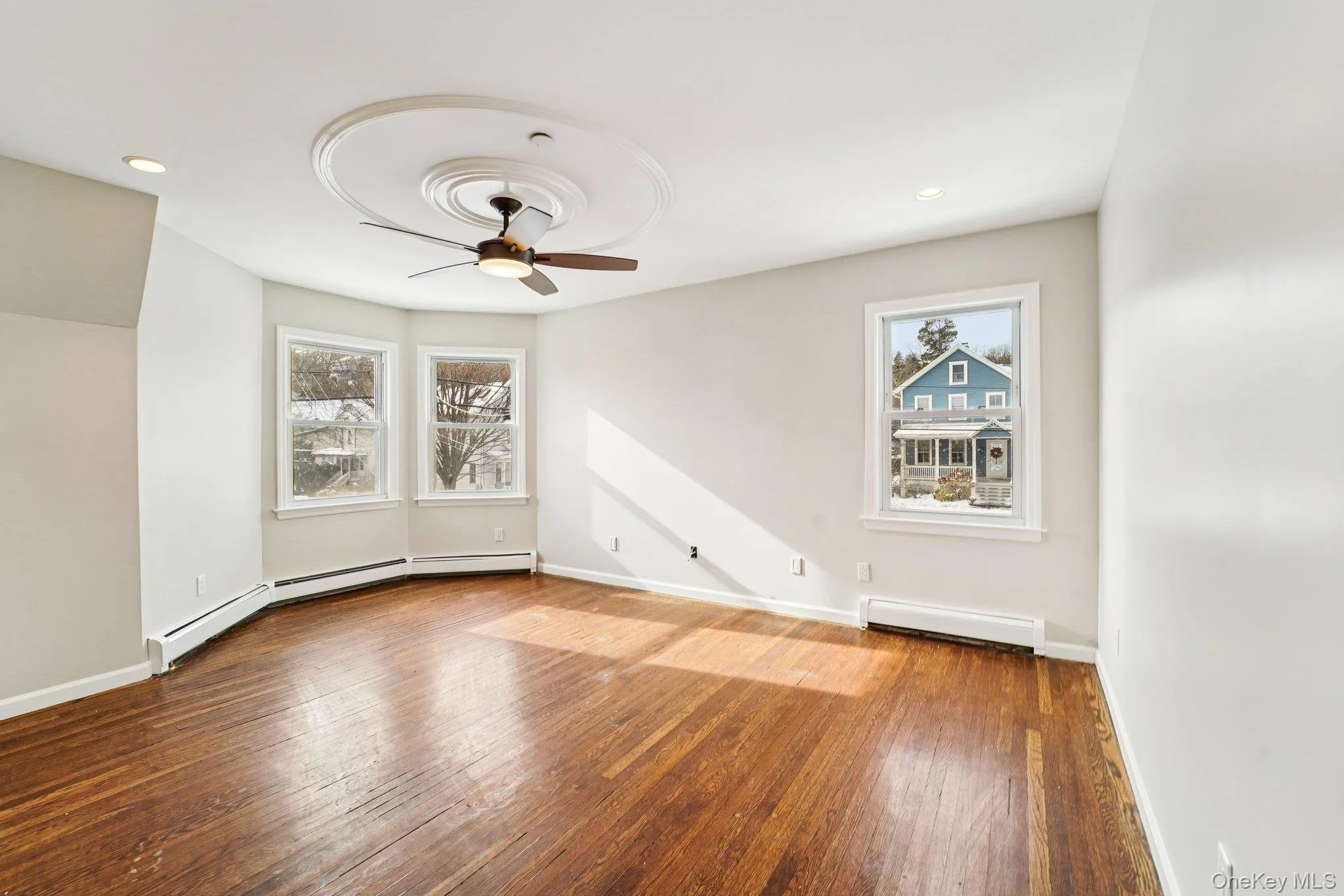 Spare room featuring hardwood / wood-style floors, ceiling fan, a baseboard heating unit, and recessed lighting Spare room featuring hardwood / wood-style floors, ceiling fan, a baseboard heating unit, and recessed lighting