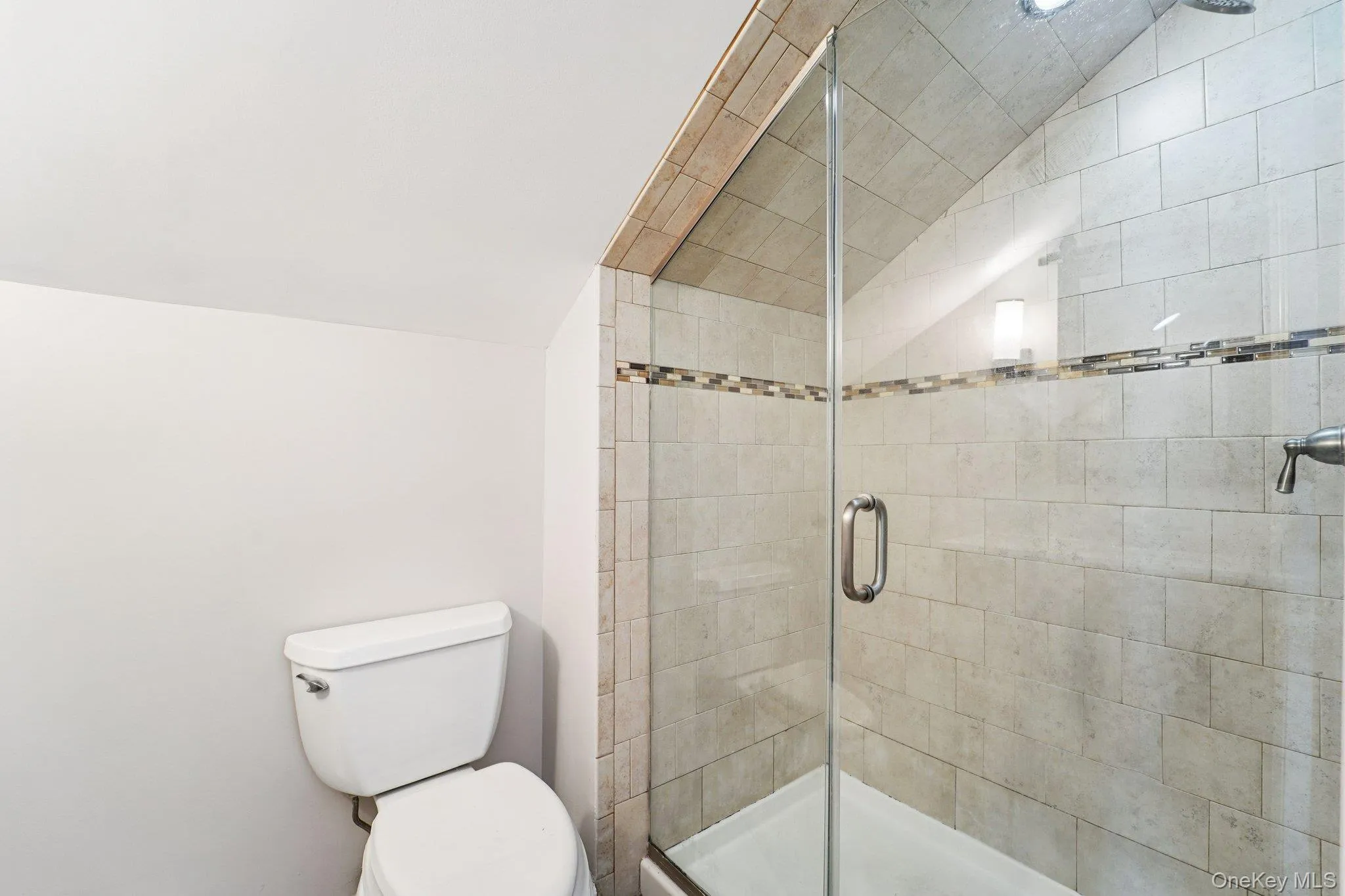 Full bathroom featuring a shower stall and vaulted ceiling Full bathroom featuring a shower stall and vaulted ceiling