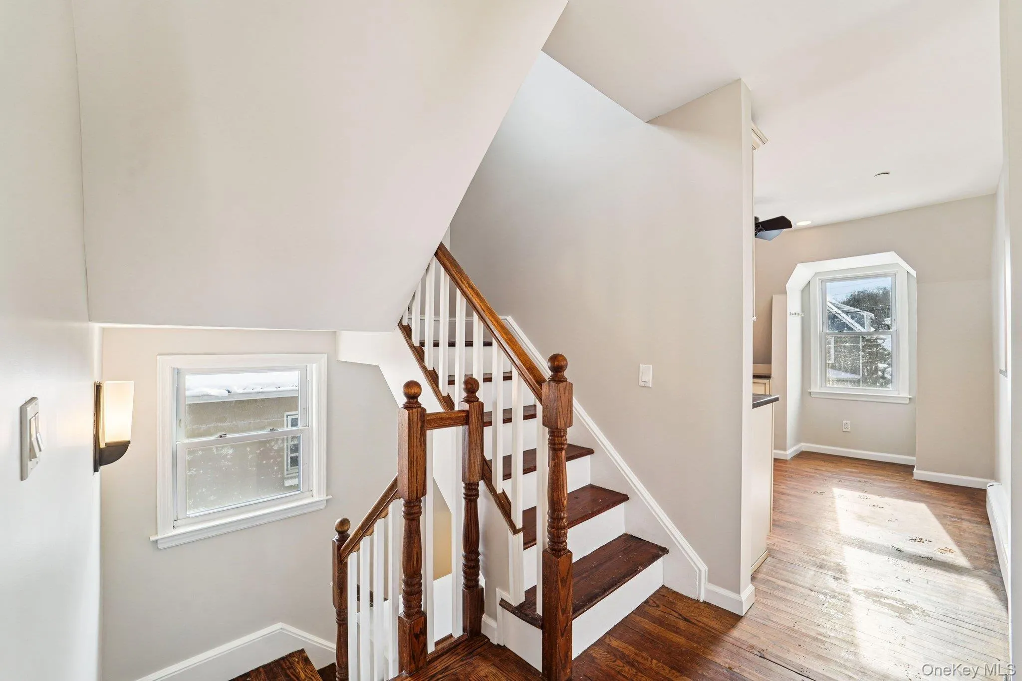 Staircase with natural light and hardwood / wood-style floors Staircase with natural light and hardwood / wood-style floors
