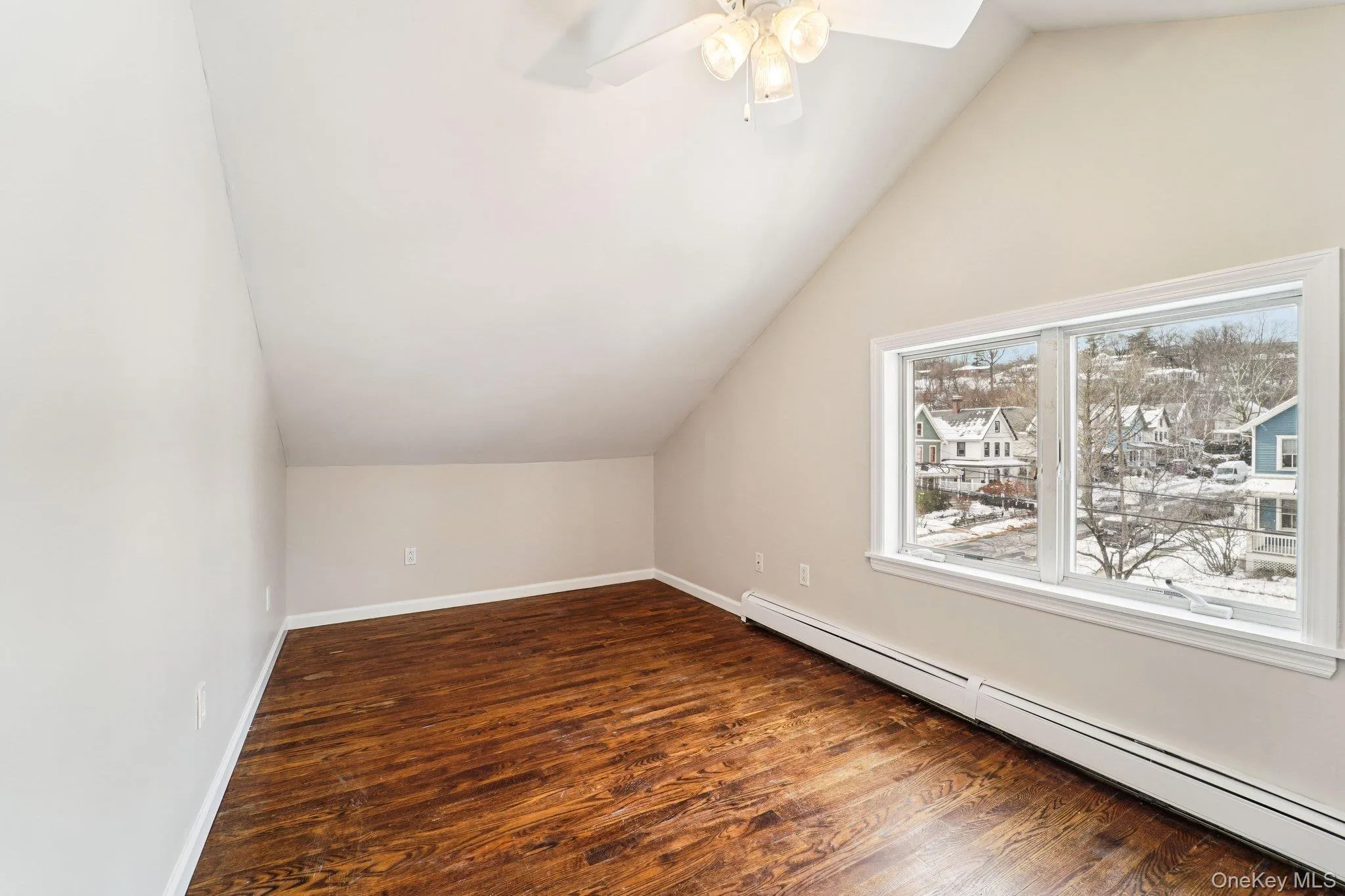 Bonus room with a baseboard radiator, lofted ceiling, dark wood finished floors, and ceiling fan Bonus room with a baseboard radiator, lofted ceiling, dark wood finished floors, and ceiling fan