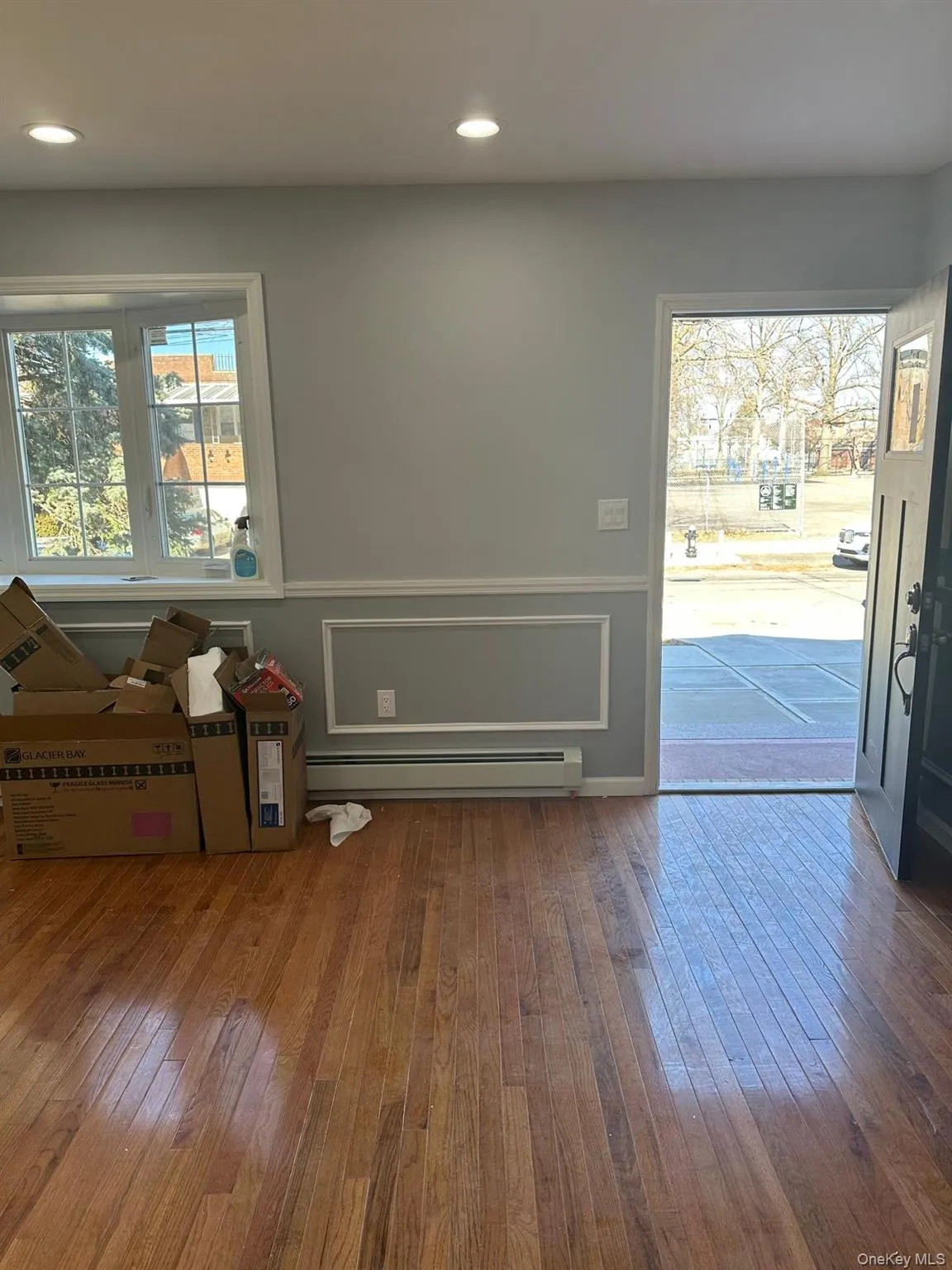 Foyer featuring a wainscoted wall, hardwood / wood-style flooring, a decorative wall, baseboard heating, and recessed lighting Foyer featuring a wainscoted wall, hardwood / wood-style flooring, a decorative wall, baseboard heating, and recessed lighting