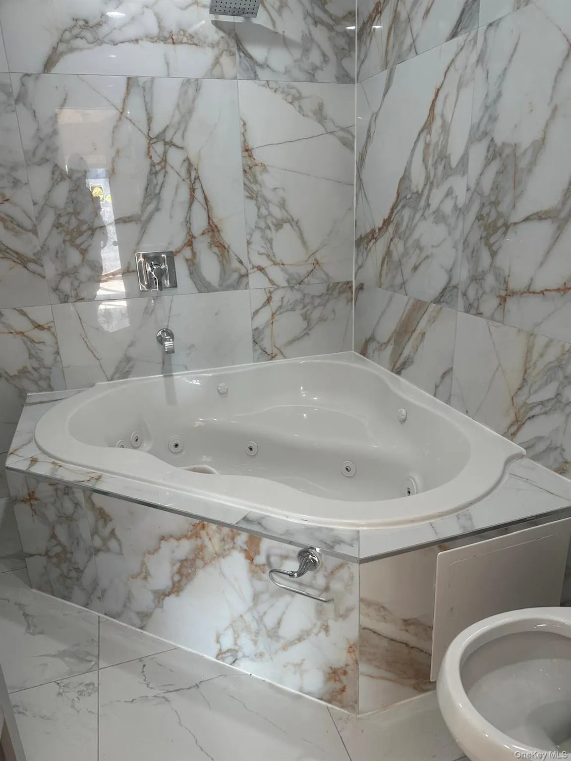 Full bathroom with marble finish flooring and a whirlpool tub Full bathroom with marble finish flooring and a whirlpool tub