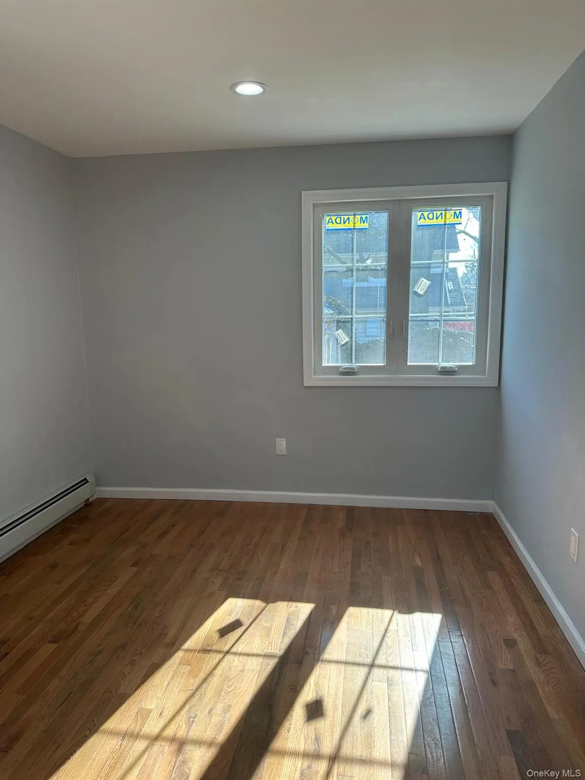 Unfurnished room with a baseboard heating unit, dark wood-type flooring, and recessed lighting Unfurnished room with a baseboard heating unit, dark wood-type flooring, and recessed lighting