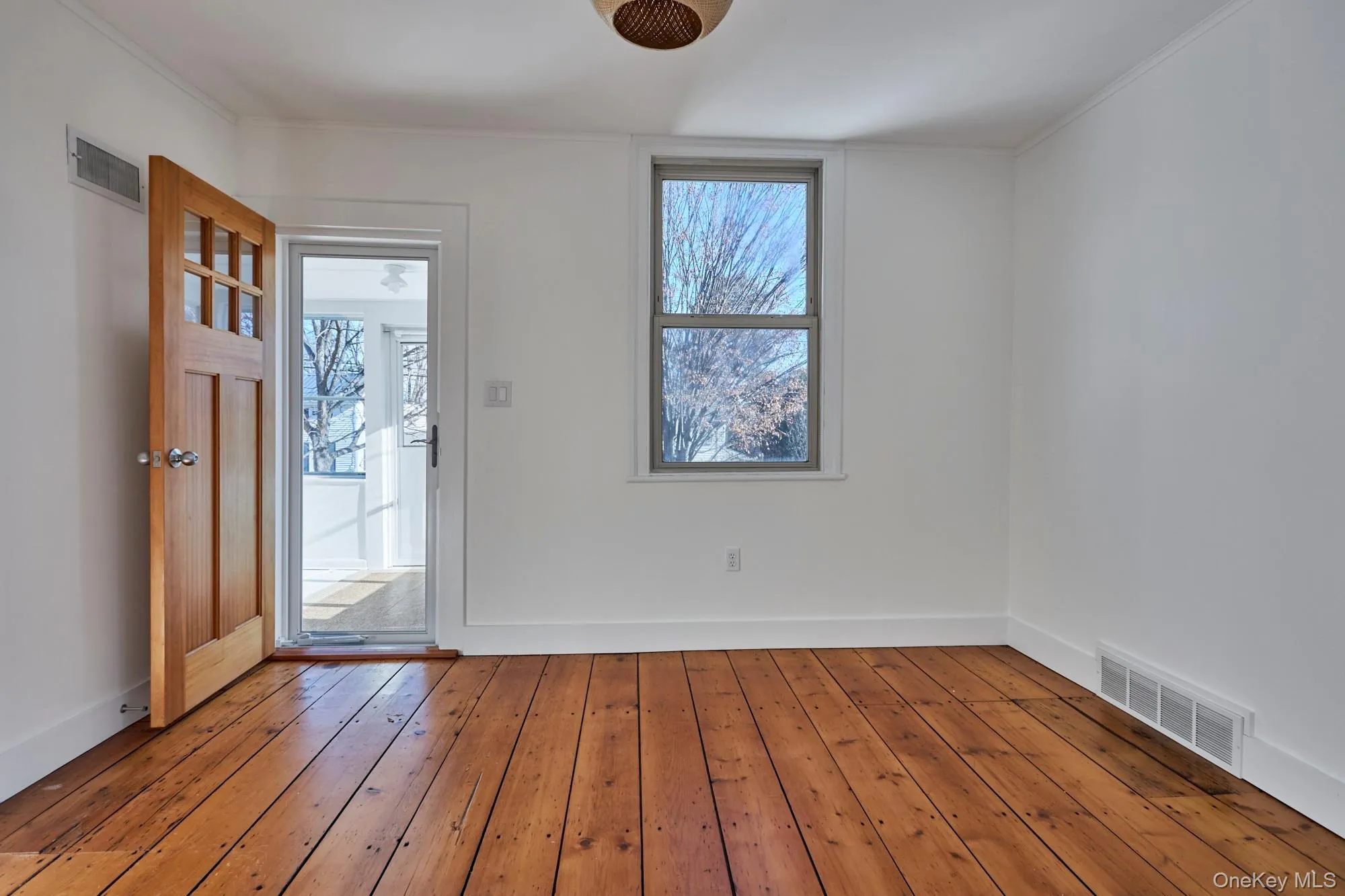 Entrance foyer with plenty of natural light, wood-type flooring, and ornamental molding Entrance foyer with plenty of natural light, wood-type flooring, and ornamental molding
