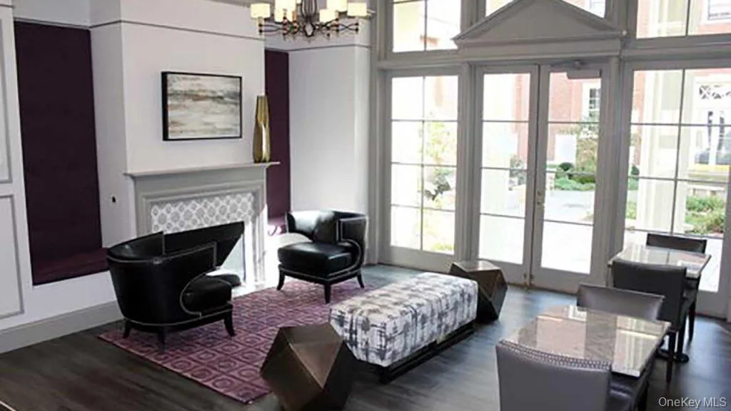 Living room with a chandelier, dark wood finished floors, and a tile fireplace Living room with a chandelier, dark wood finished floors, and a tile fireplace