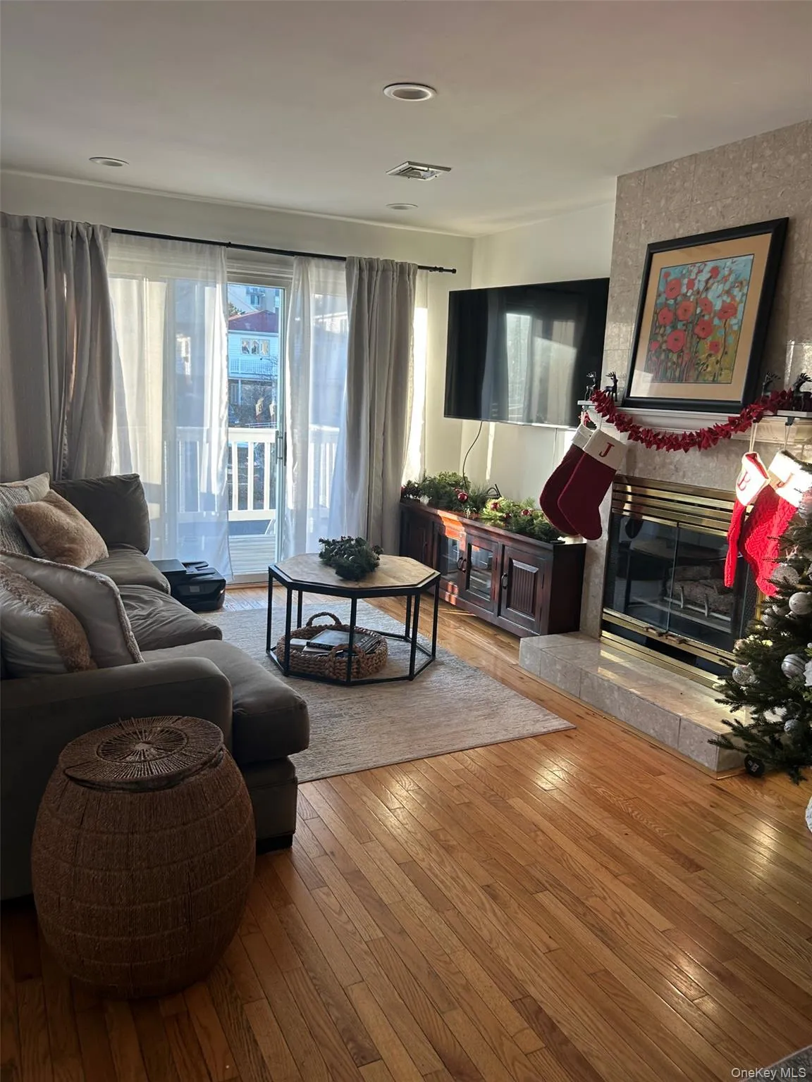 Living room featuring a large fireplace and hardwood / wood-style floors Living room featuring a large fireplace and hardwood / wood-style floors