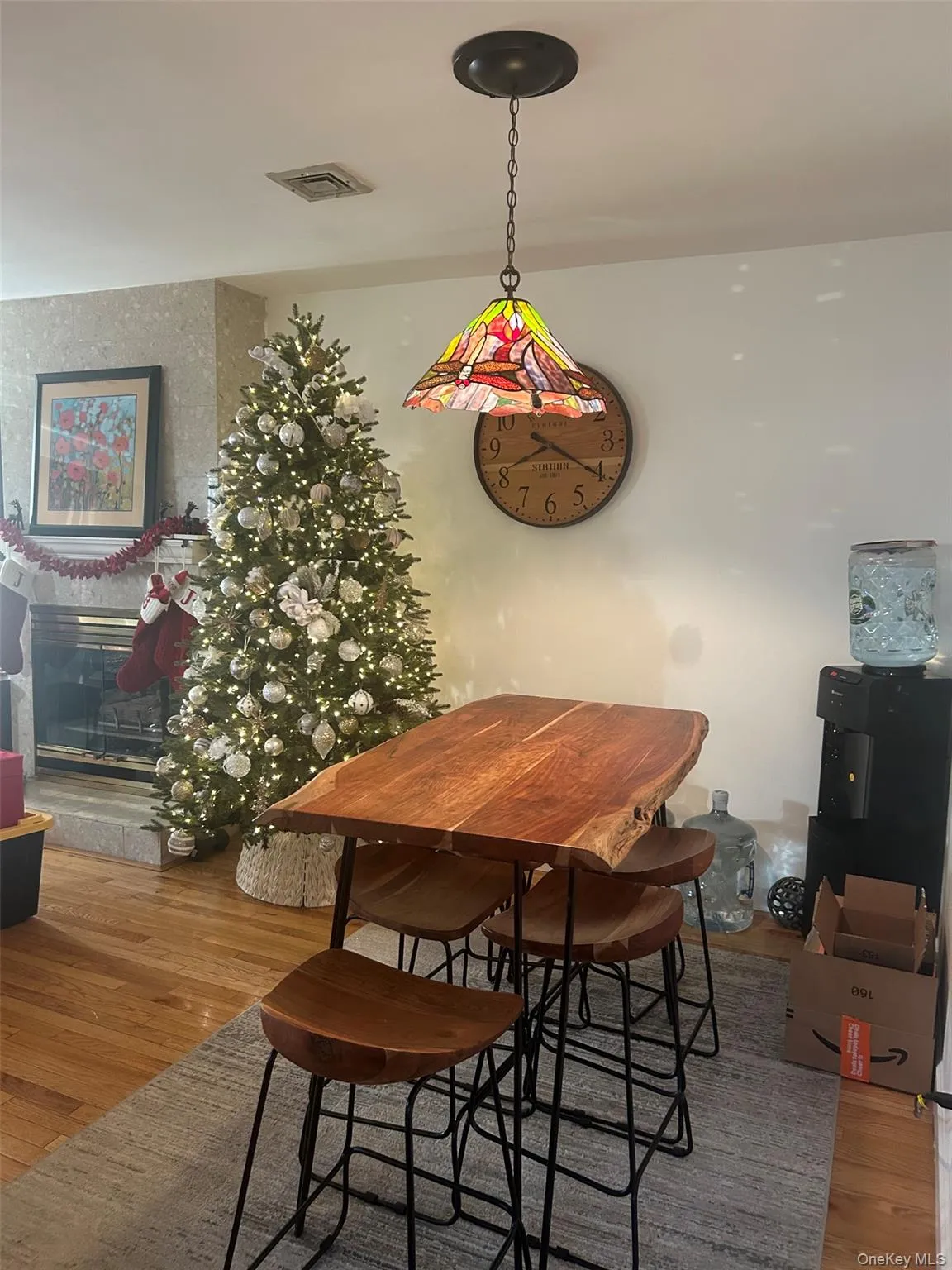 Dining room with light wood-style flooring and a glass covered fireplace Dining room with light wood-style flooring and a glass covered fireplace