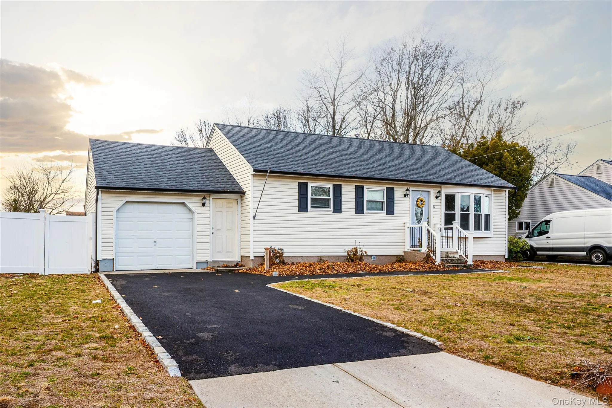 Ranch-style home featuring a shingled roof, asphalt driveway, and an attached garage Ranch-style home featuring a shingled roof, asphalt driveway, and an attached garage
