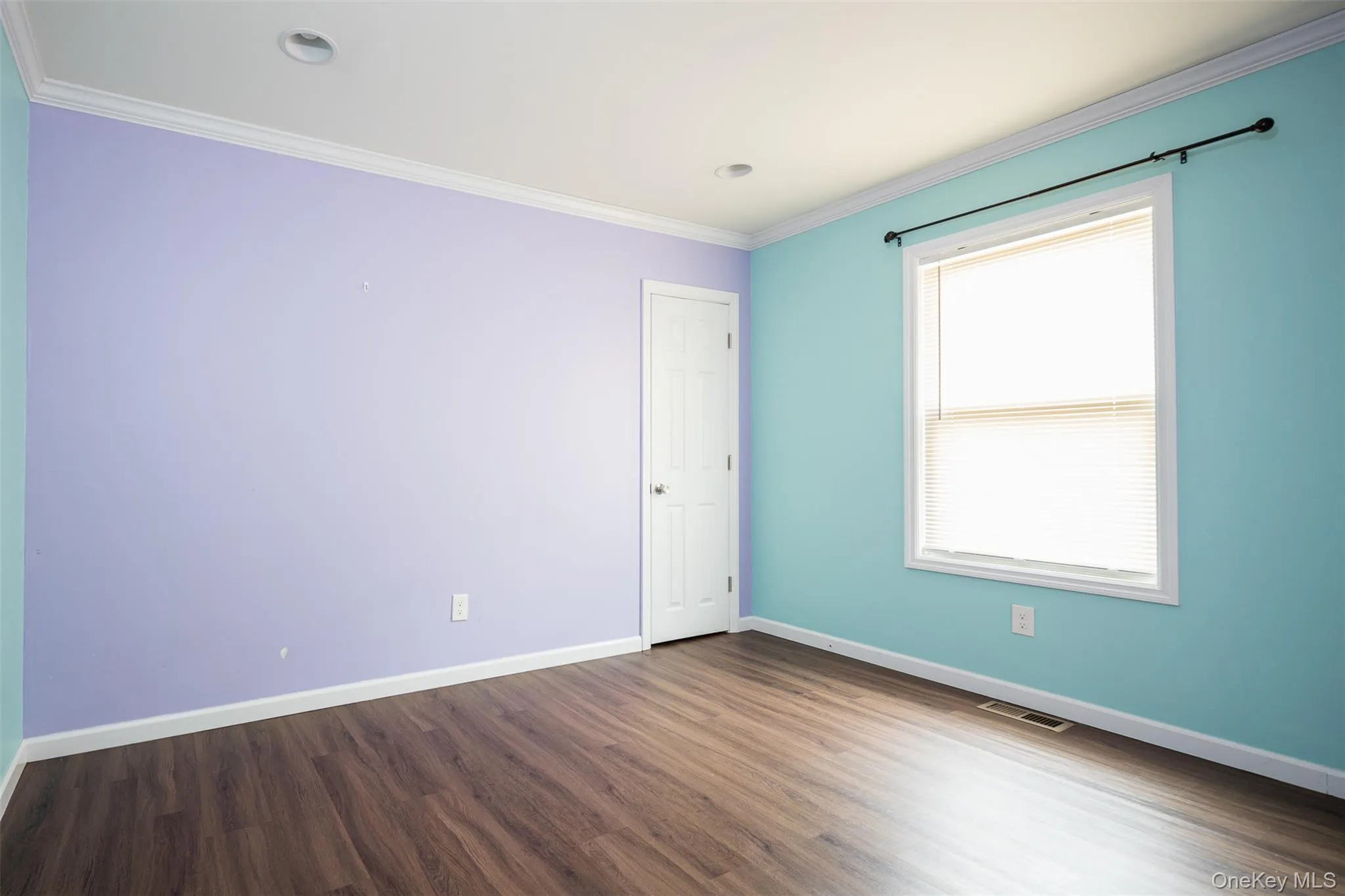 Spare room with dark wood-style flooring and crown molding Spare room with dark wood-style flooring and crown molding