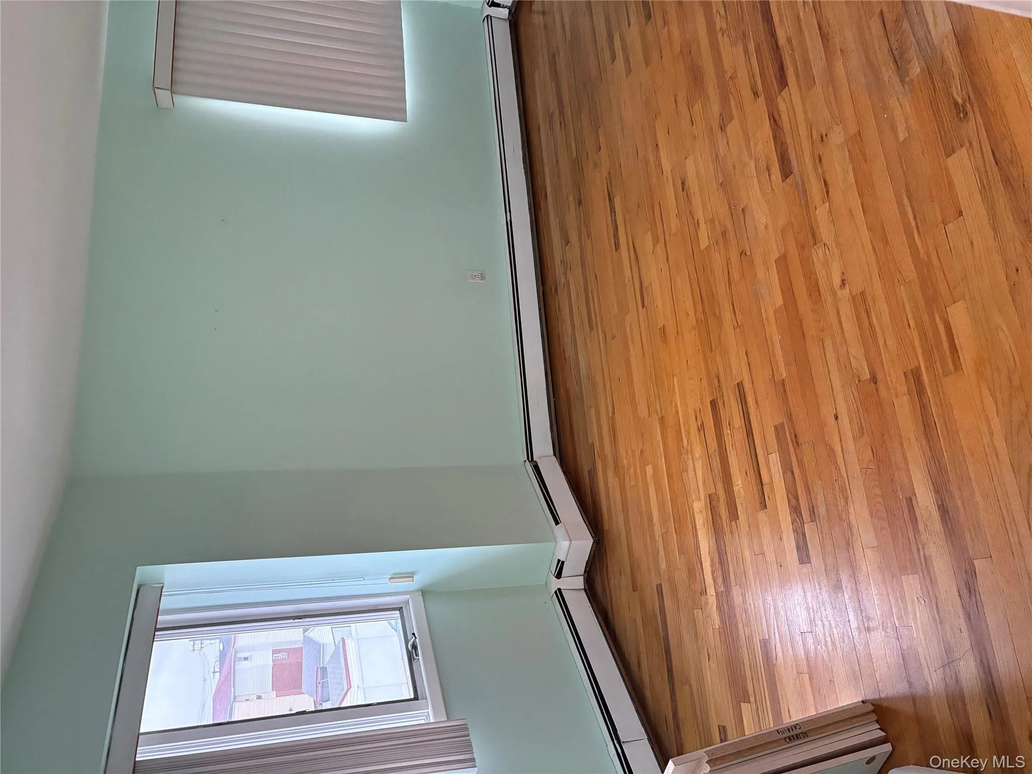 Empty room featuring light wood-style floors and a baseboard radiator Empty room featuring light wood-style floors and a baseboard radiator