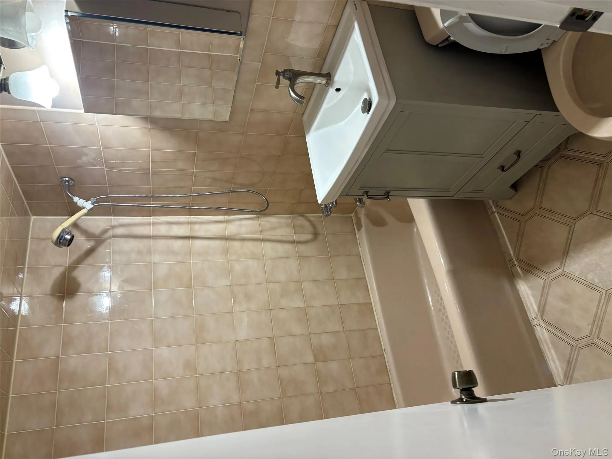 Full bath featuring shower / tub combination, vanity, tile walls, and backsplash Full bath featuring shower / tub combination, vanity, tile walls, and backsplash