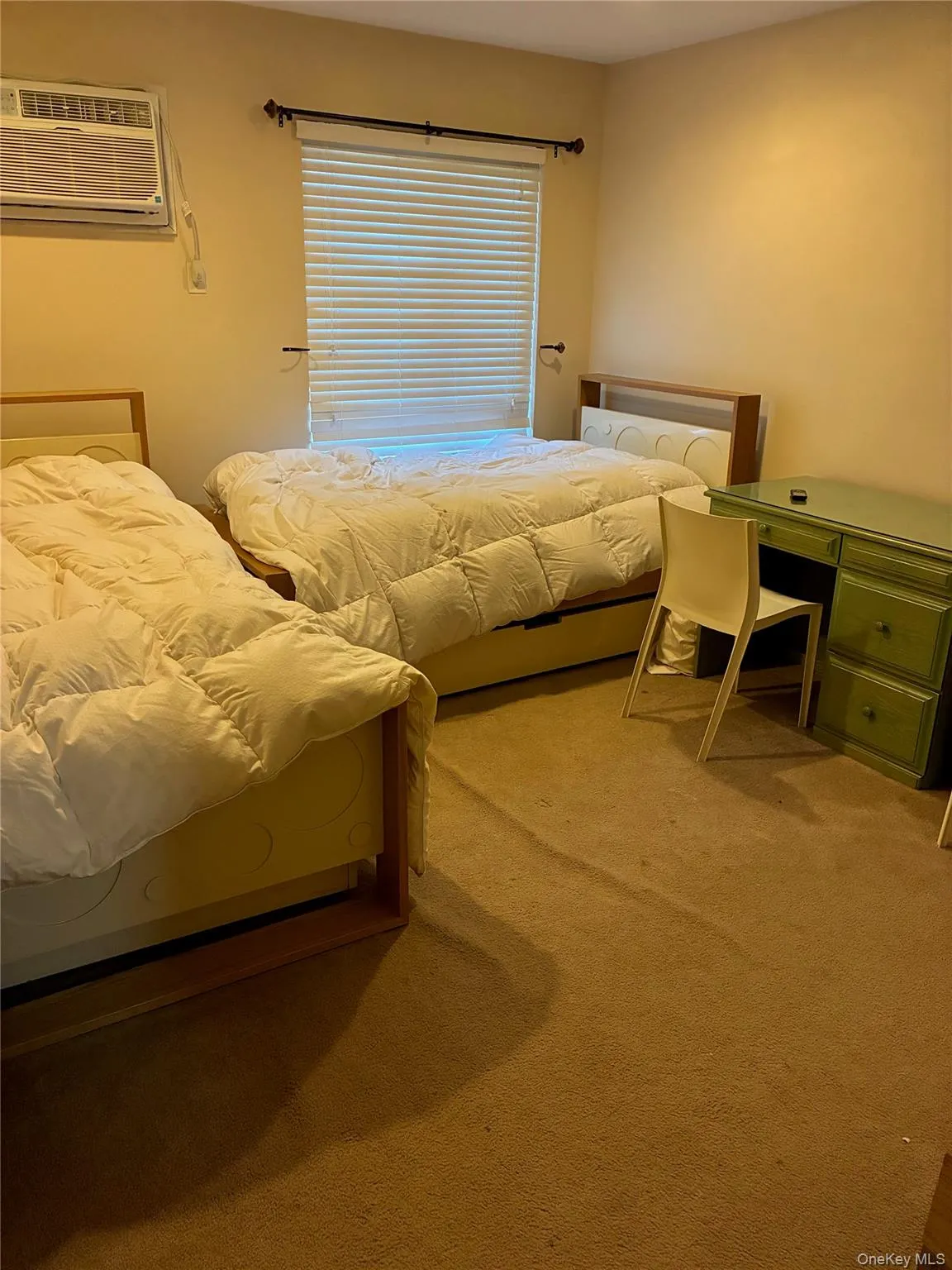 Bedroom featuring carpet and a new AC wall unit Bedroom featuring carpet and a new AC wall unit