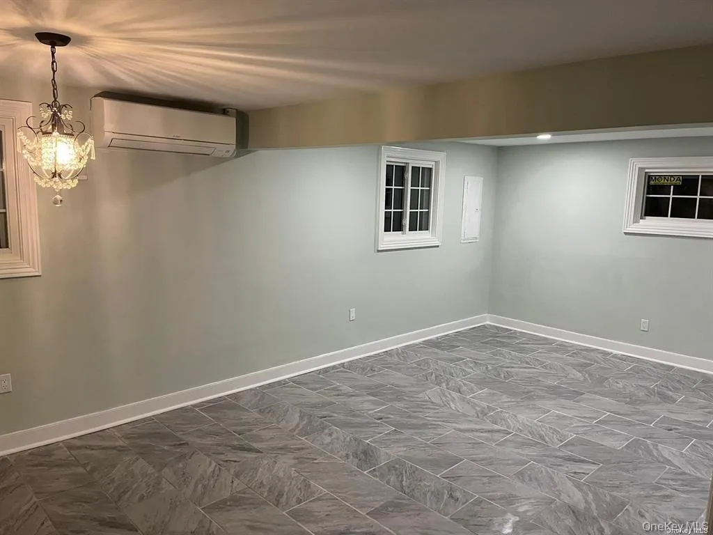Unfurnished room with a wall unit AC, a chandelier, and recessed lighting Unfurnished room with a wall unit AC, a chandelier, and recessed lighting
