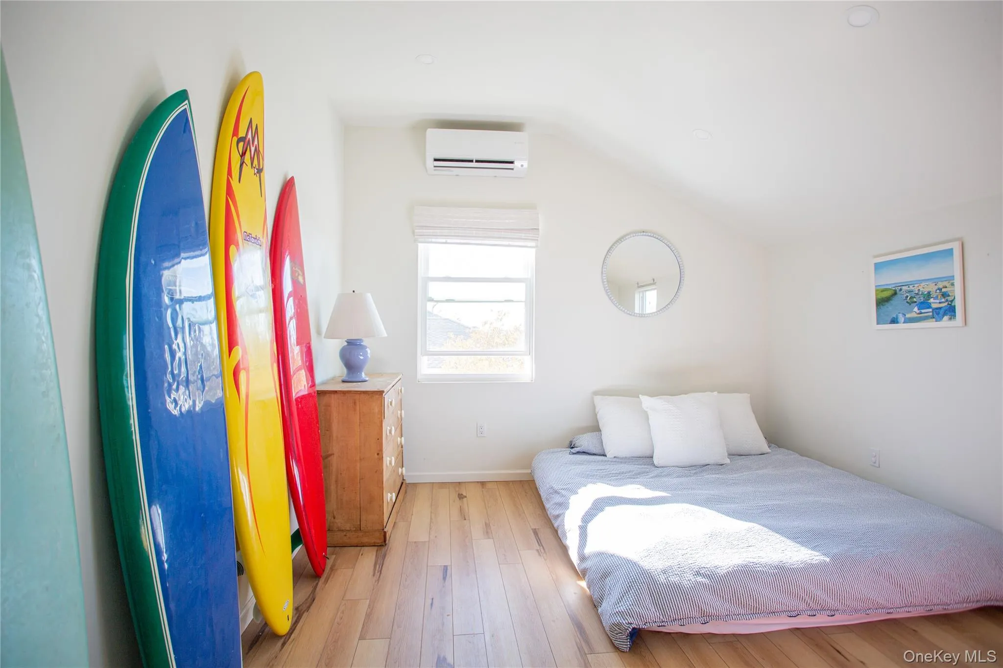 Bedroom featuring lofted ceiling, hardwood / wood-style floors, and a wall mounted AC Bedroom featuring lofted ceiling, hardwood / wood-style floors, and a wall mounted AC