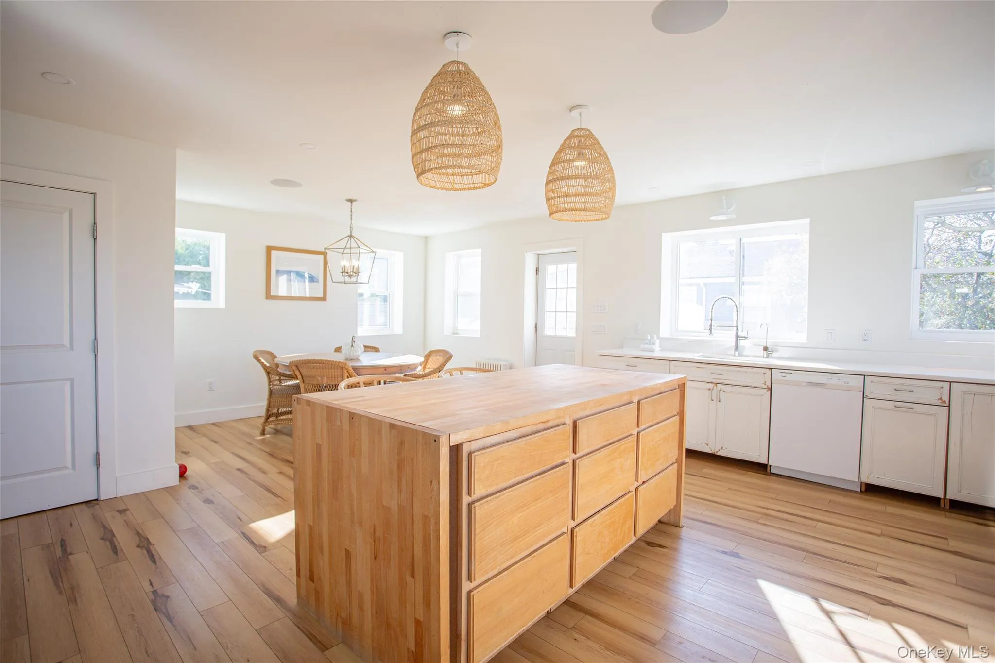 Kitchen featuring a kitchen island, wooden counters, dishwasher, and light wood-style floors Kitchen featuring a kitchen island, wooden counters, dishwasher, and light wood-style floors