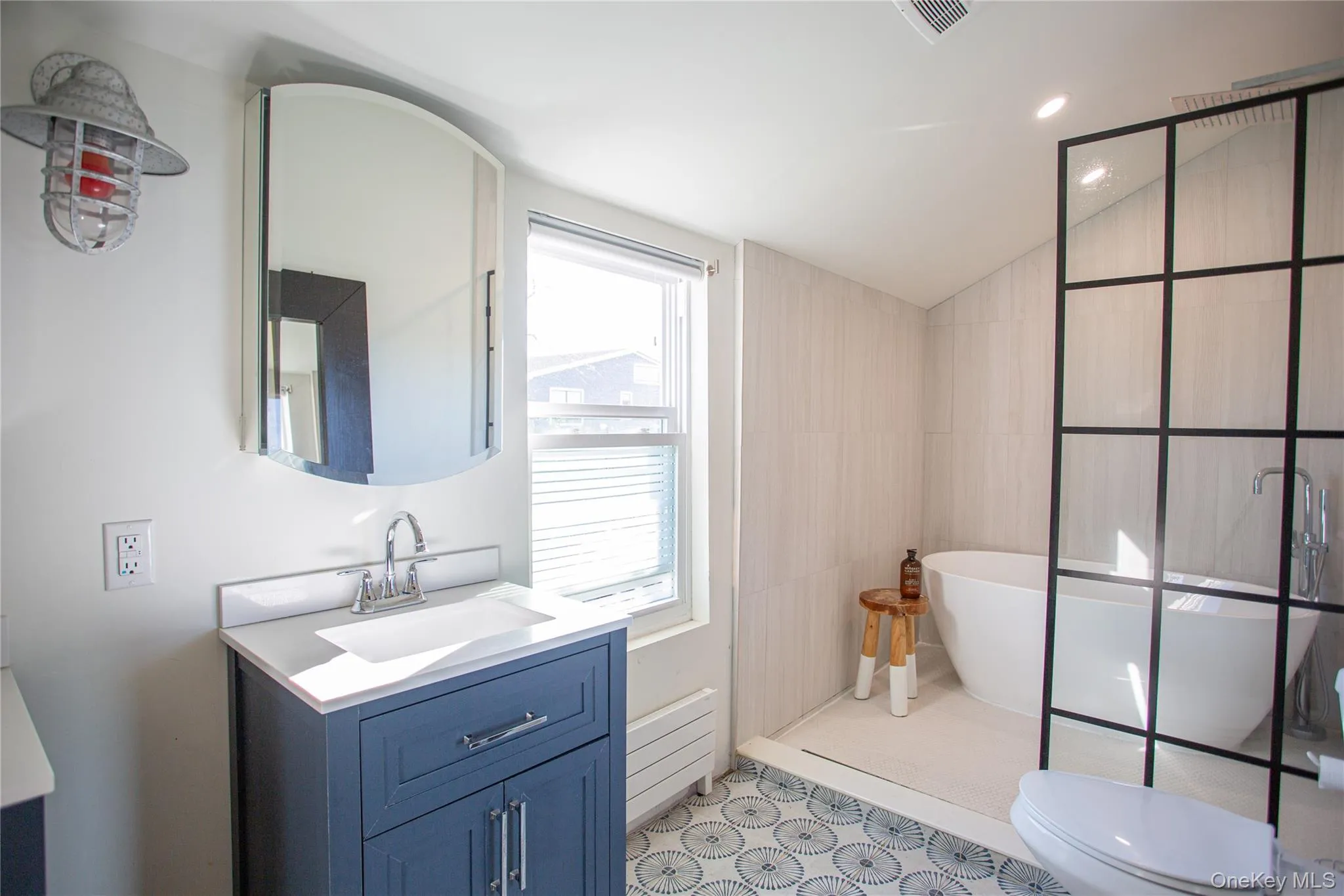Bathroom with vanity, a soaking tub, vaulted ceiling, recessed lighting, and light floors Bathroom with vanity, a soaking tub, vaulted ceiling, recessed lighting, and light floors