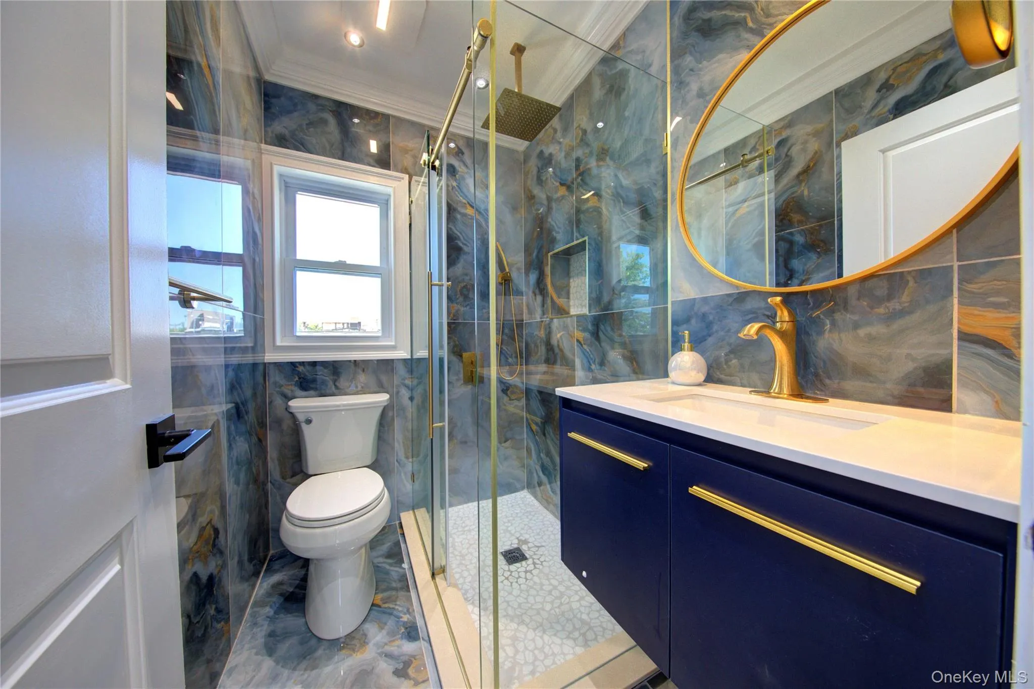 Bathroom with tile walls, vanity, crown molding, and a marble finish shower Bathroom with tile walls, vanity, crown molding, and a marble finish shower