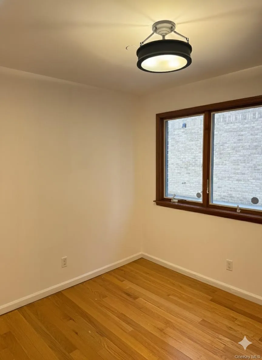 Spare room featuring light wood-style floors and baseboards Spare room featuring light wood-style floors and baseboards