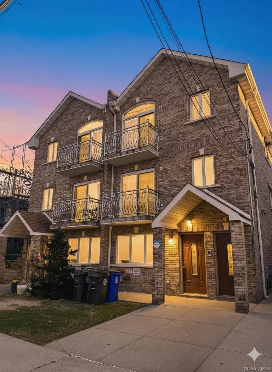 View of front of home featuring a balcony and brick siding View of front of home featuring a balcony and brick siding