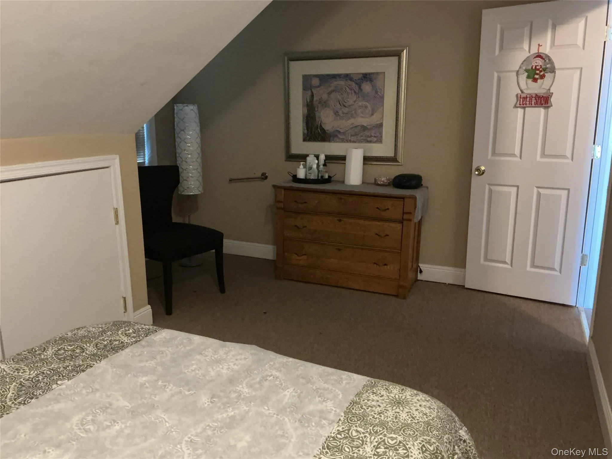 Carpeted bedroom with lofted ceiling and baseboards Carpeted bedroom with lofted ceiling and baseboards