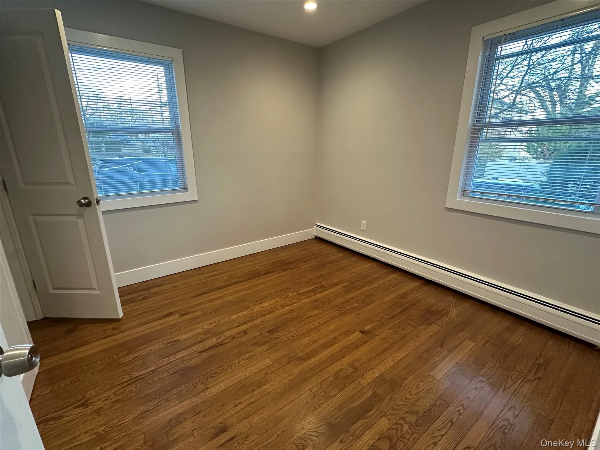 Spare room featuring a baseboard radiator, dark wood finished floors, and recessed lighting Spare room featuring a baseboard radiator, dark wood finished floors, and recessed lighting