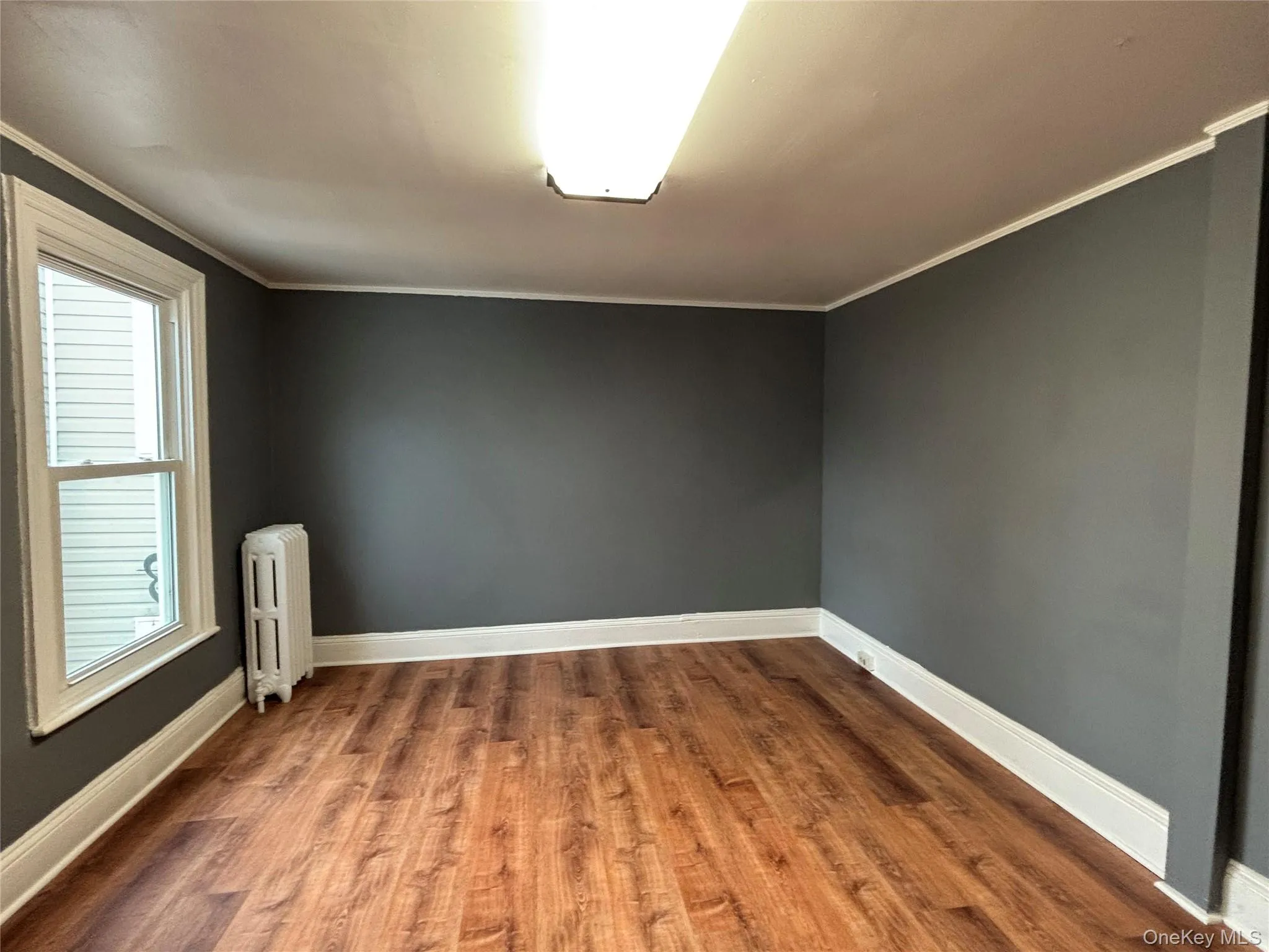 Living Room with dining area ornamental molding, and dark wood-type flooring Living Room with dining area ornamental molding, and dark wood-type flooring