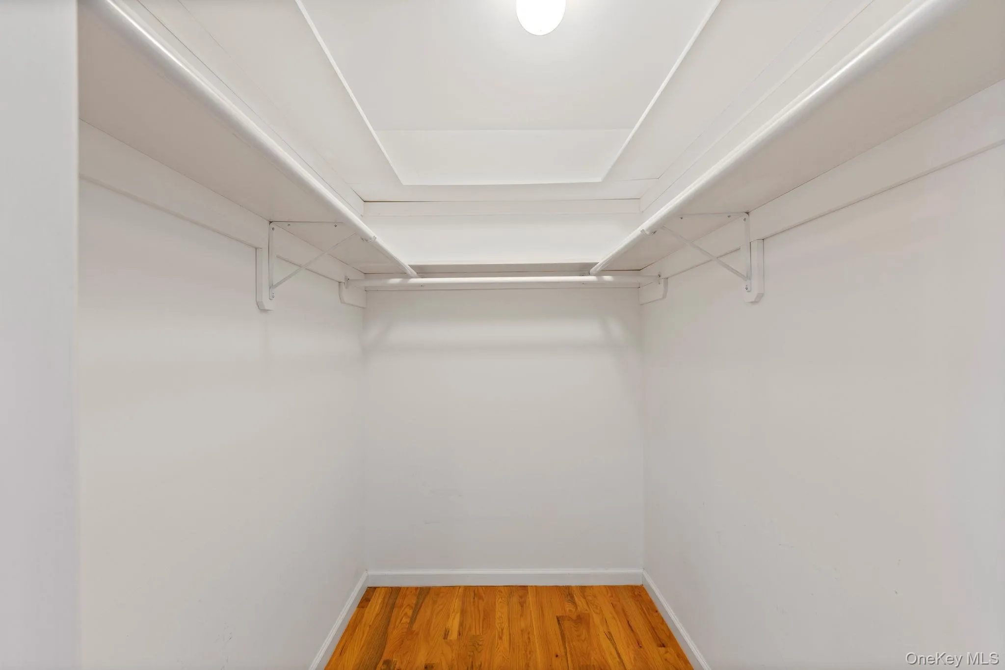 Spacious closet featuring light wood-type flooring Spacious closet featuring light wood-type flooring