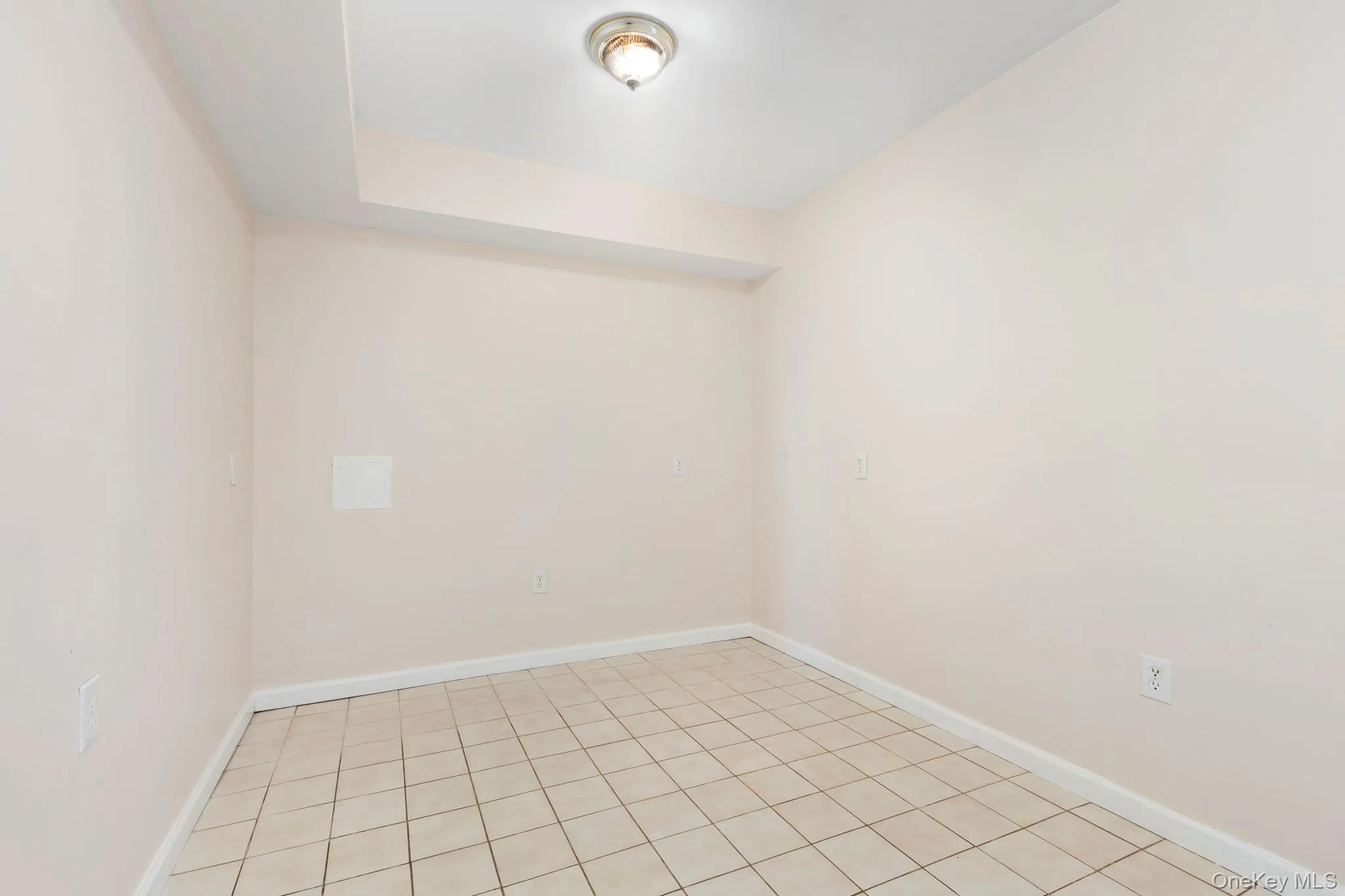 Tiled spare room featuring baseboards Tiled spare room featuring baseboards