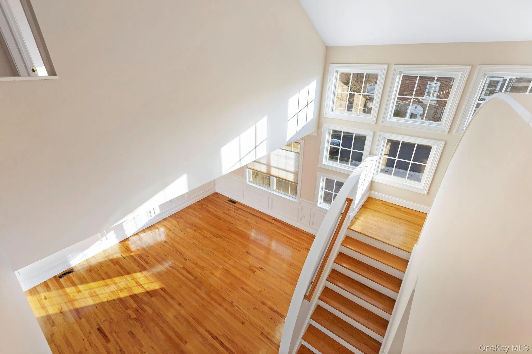 Staircase featuring hardwood / wood-style floors and a towering ceiling Staircase featuring hardwood / wood-style floors and a towering ceiling