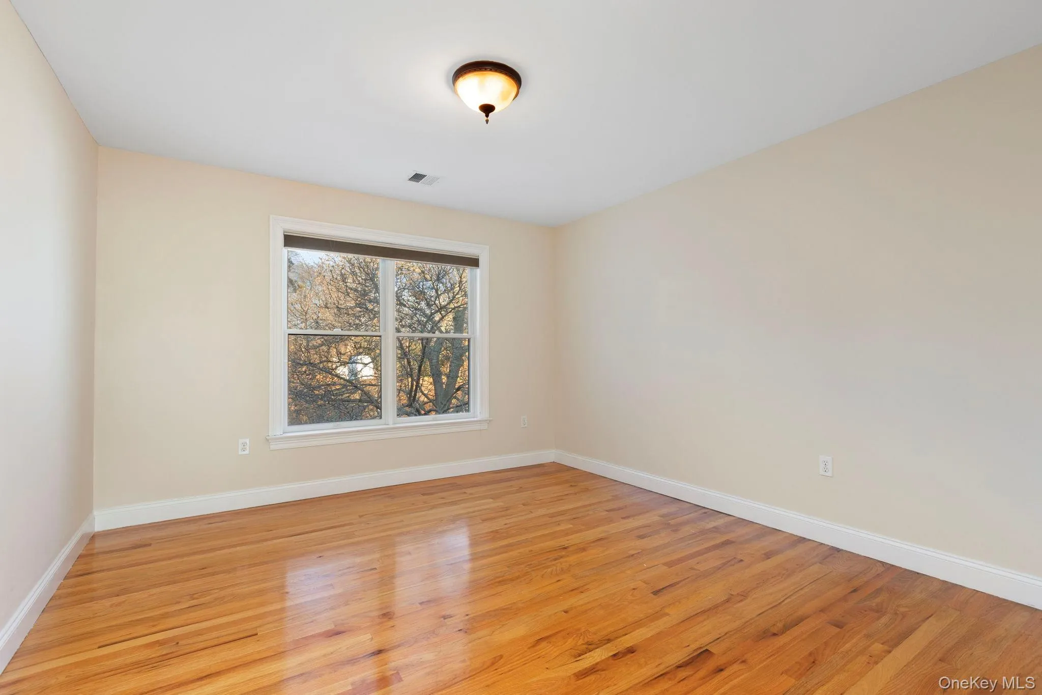 Spare room with baseboards and light wood-style flooring Spare room with baseboards and light wood-style flooring