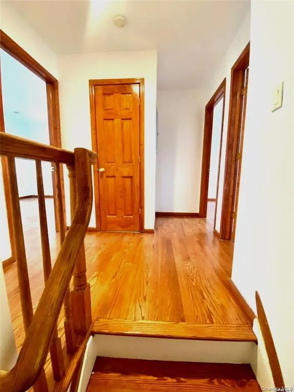 Hall with light wood-style flooring and baseboards Hall with light wood-style flooring and baseboards