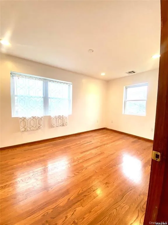 Unfurnished room with light wood-type flooring, healthy amount of natural light, and recessed lighting Unfurnished room with light wood-type flooring, healthy amount of natural light, and recessed lighting