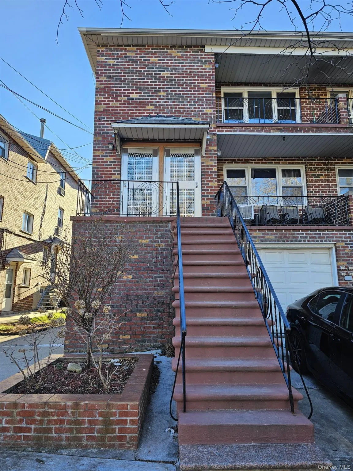 View of front of home with brick siding, stairs, and a balcony View of front of home with brick siding, stairs, and a balcony