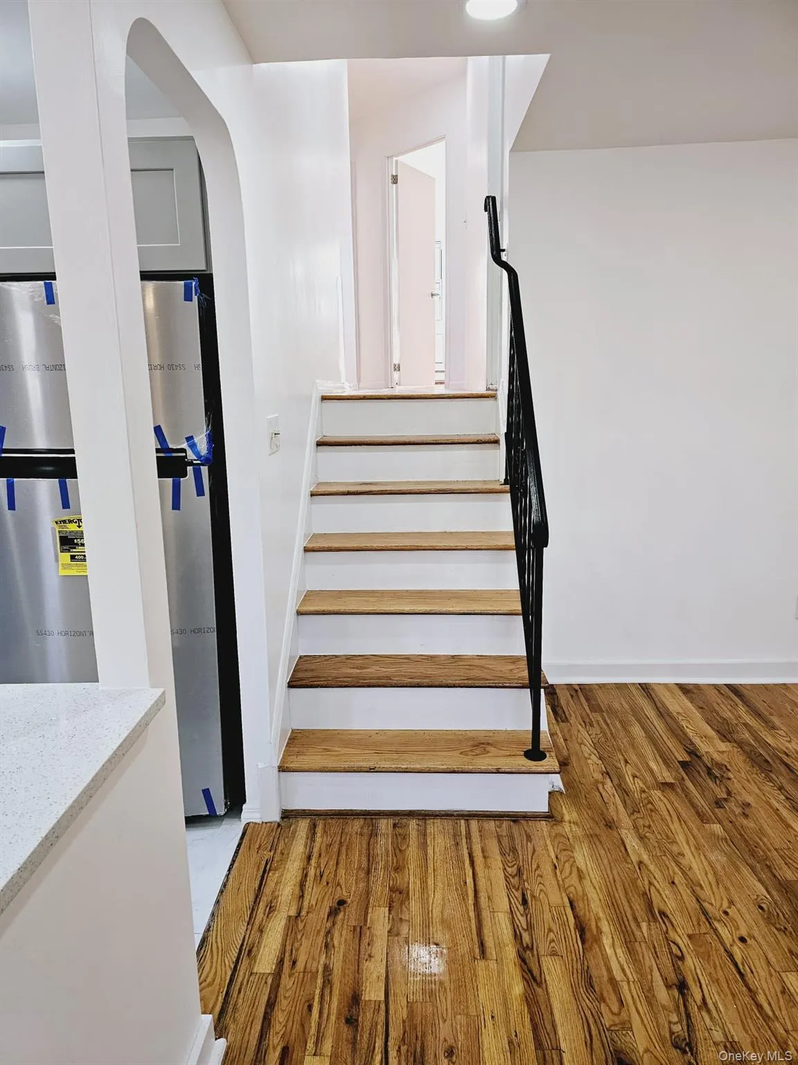 Stairway featuring wood finished floors and arched walkways Stairway featuring wood finished floors and arched walkways